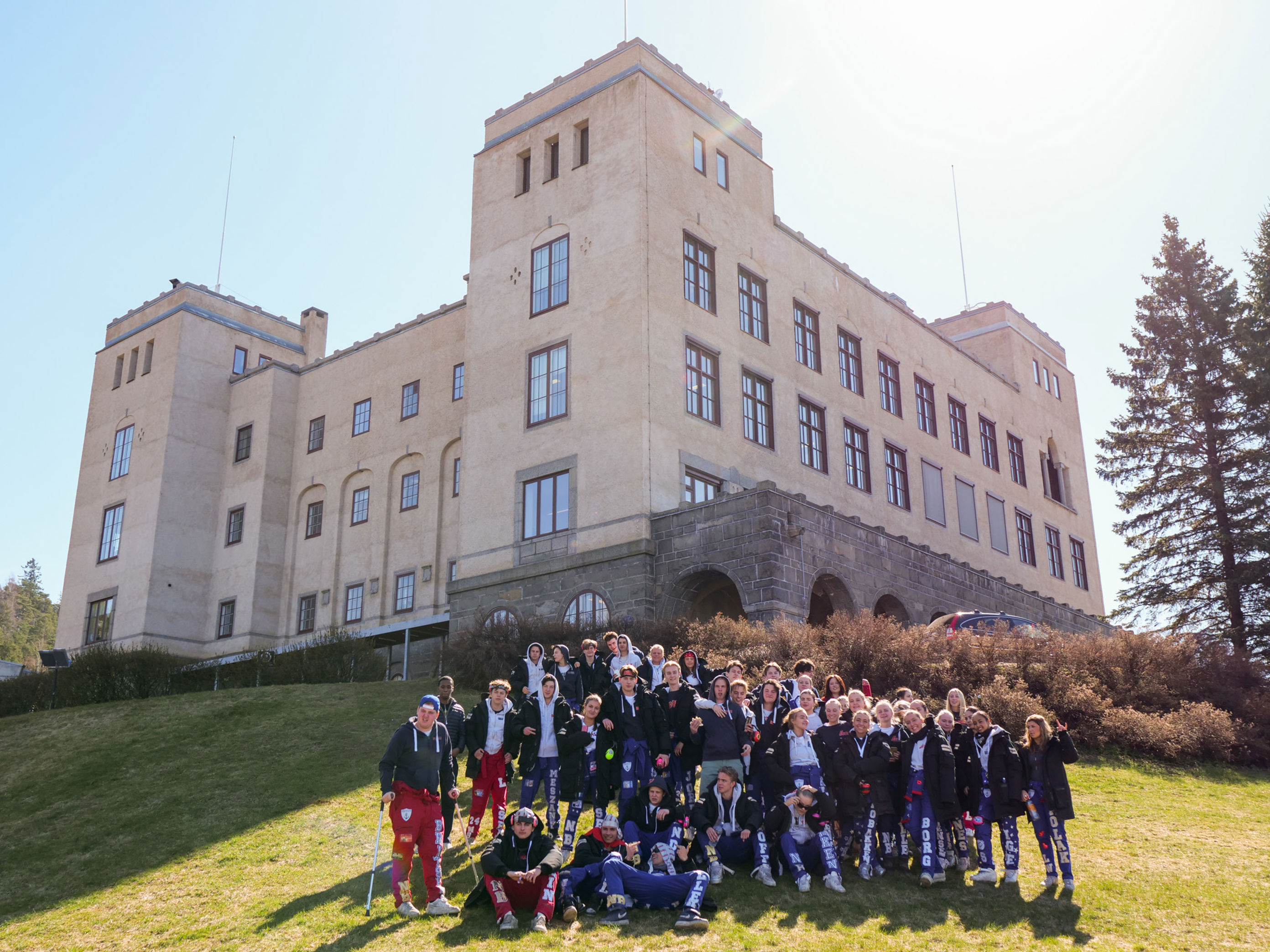 en gruppe mennesker som poserer foran en stor bygning en gruppe mennesker som poserer foran en stor bygning