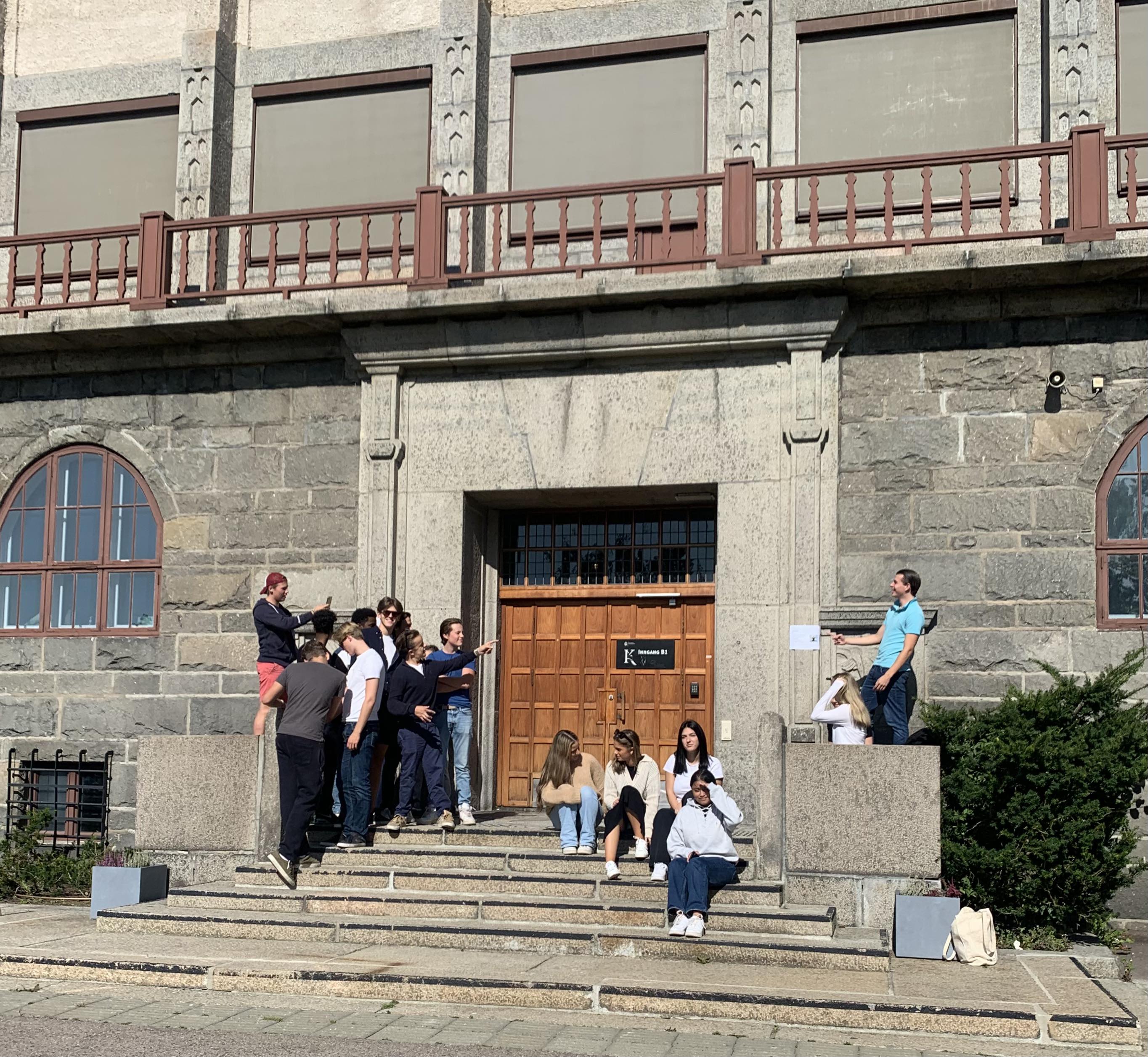 En gruppe mennesker som står på trappen utenfor en bygning