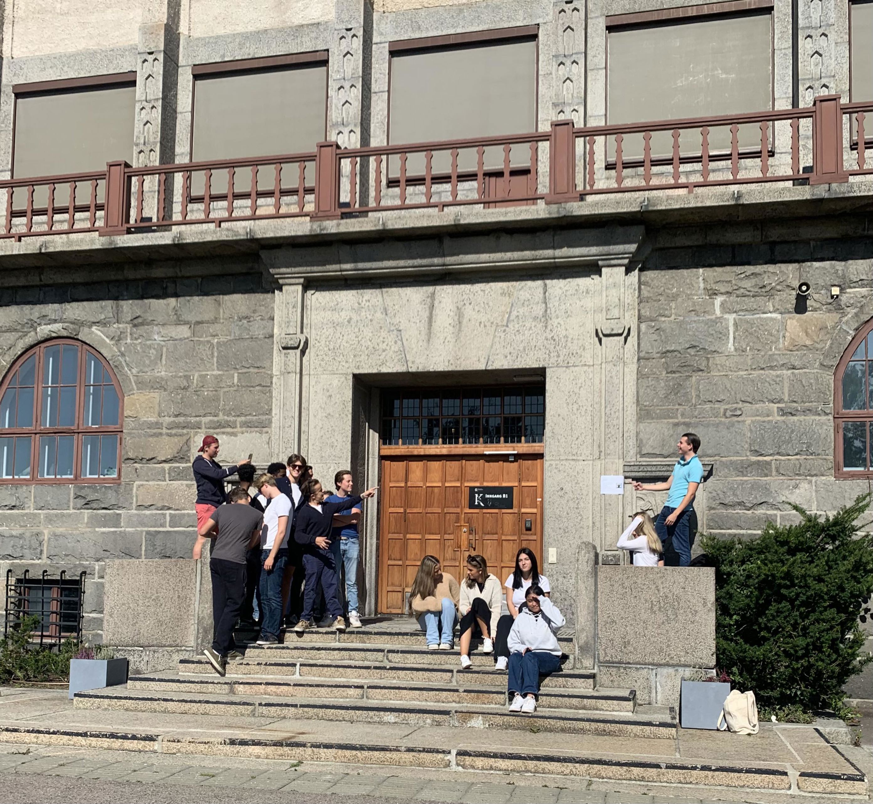 En gruppe mennesker som står på trappen utenfor en bygning En gruppe mennesker som står på trappen utenfor en bygning