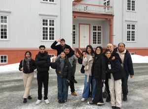 En gruppe mennesker som poserer for et bilde foran en bygning