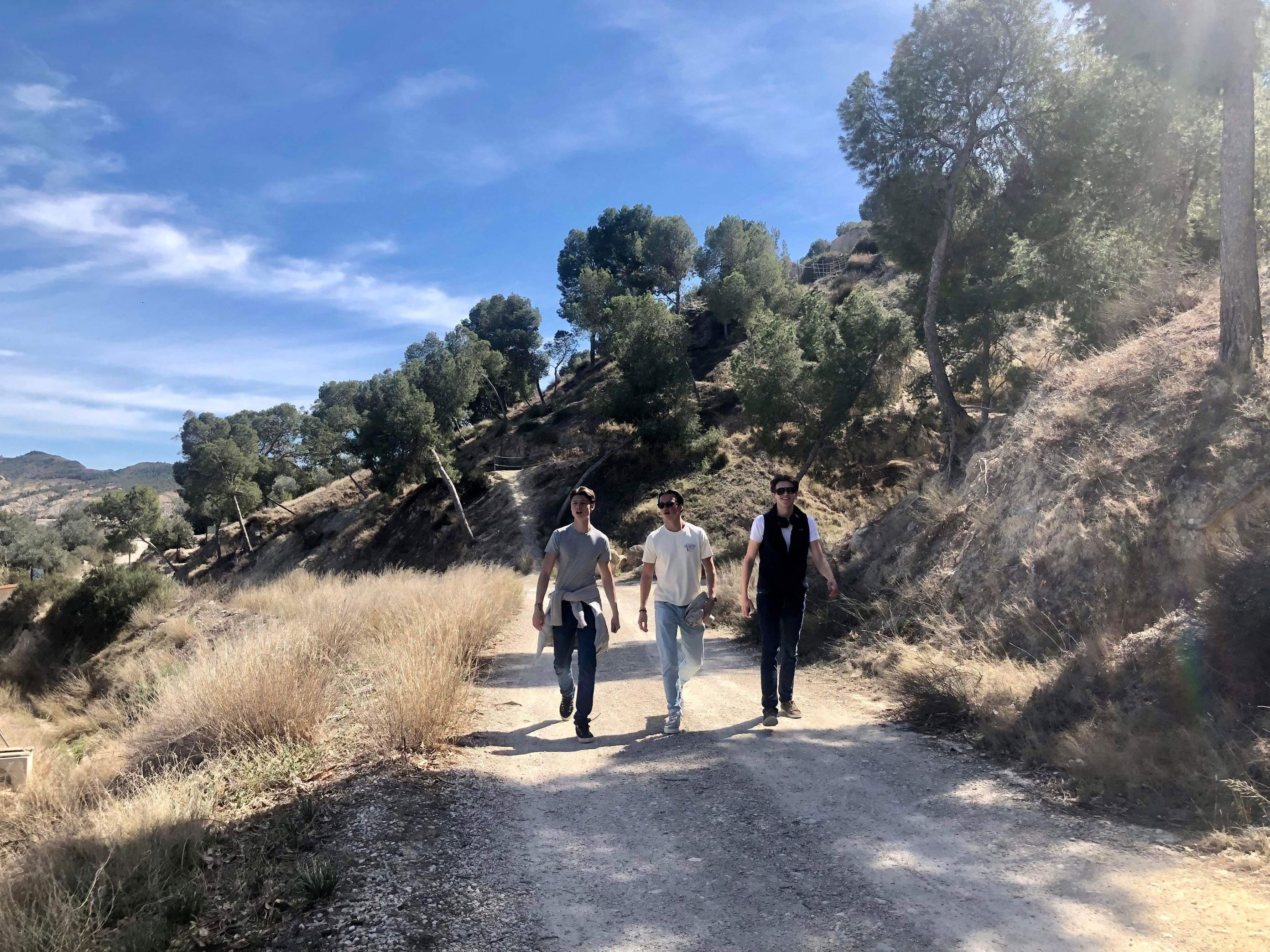 En gruppe menn som går på en grusvei En gruppe menn som går på en grusvei