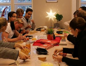 en gruppe mennesker som sitter rundt et bord og spiller kort