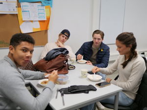 en gruppe mennesker som spiser ved et bord