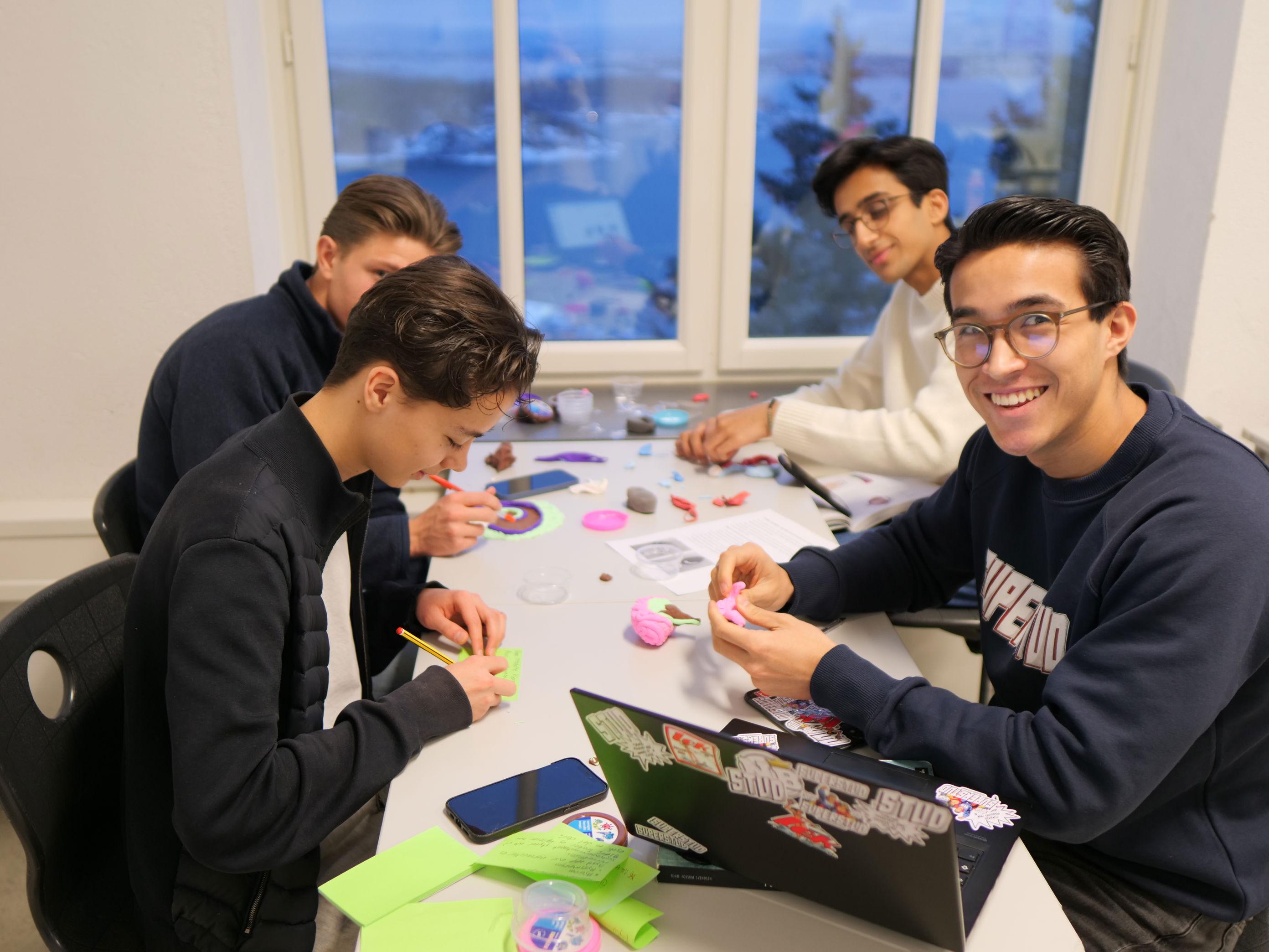 en gruppe mennesker som sitter rundt et bord med et brettspill en gruppe mennesker som sitter rundt et bord med et brettspill