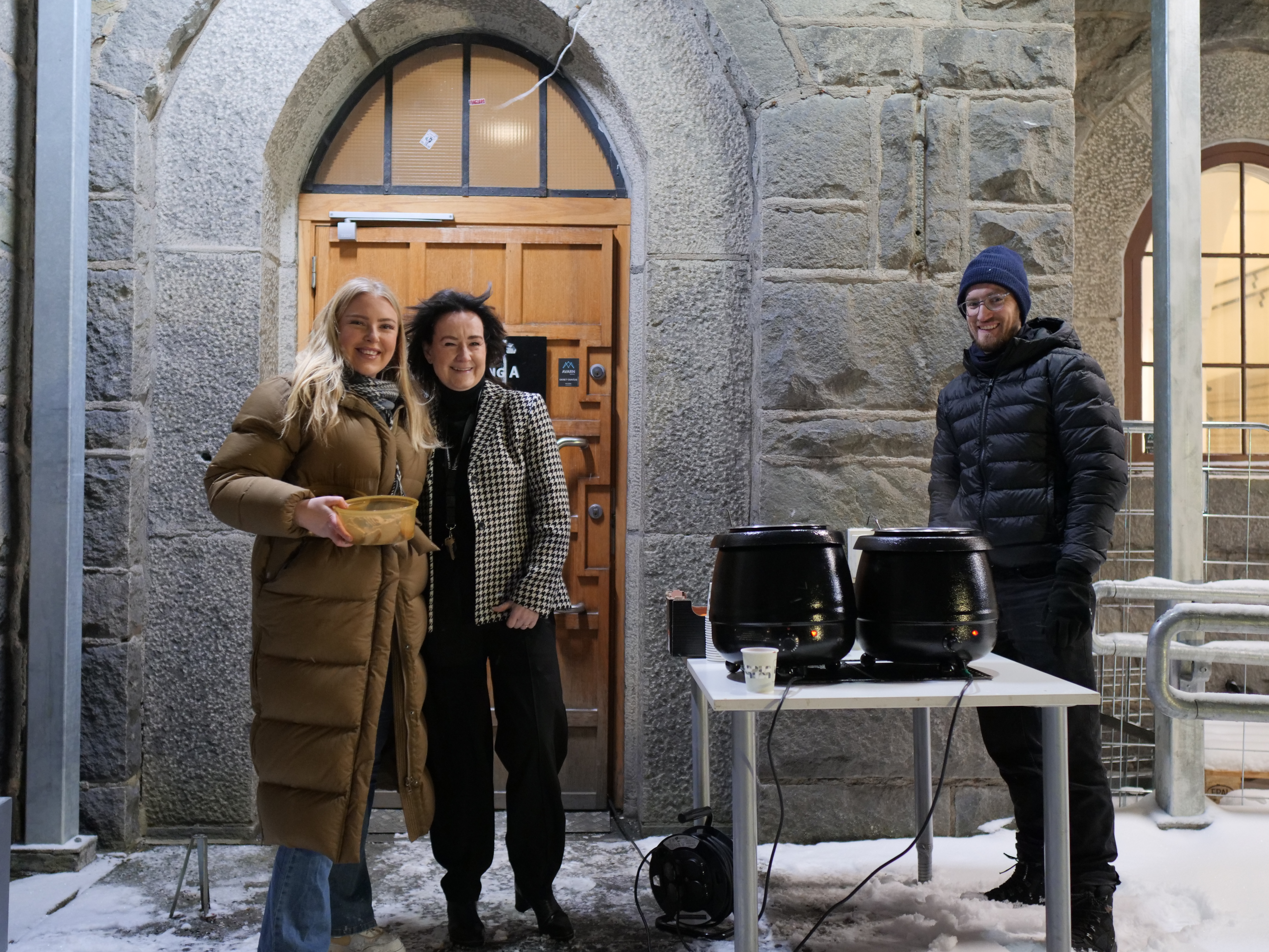 en gruppe mennesker som står utenfor en bygning
