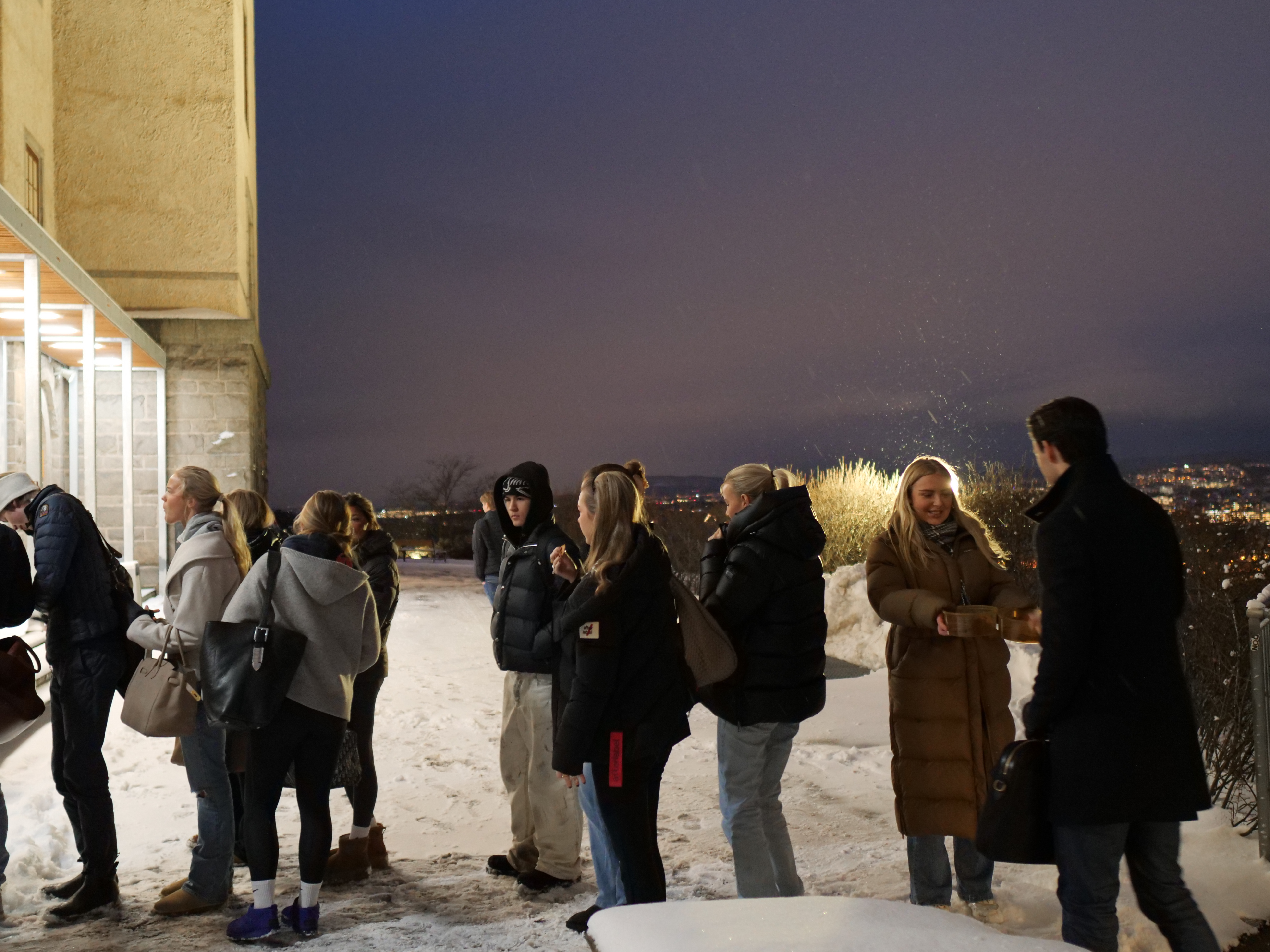 En gruppe mennesker som står i snøen