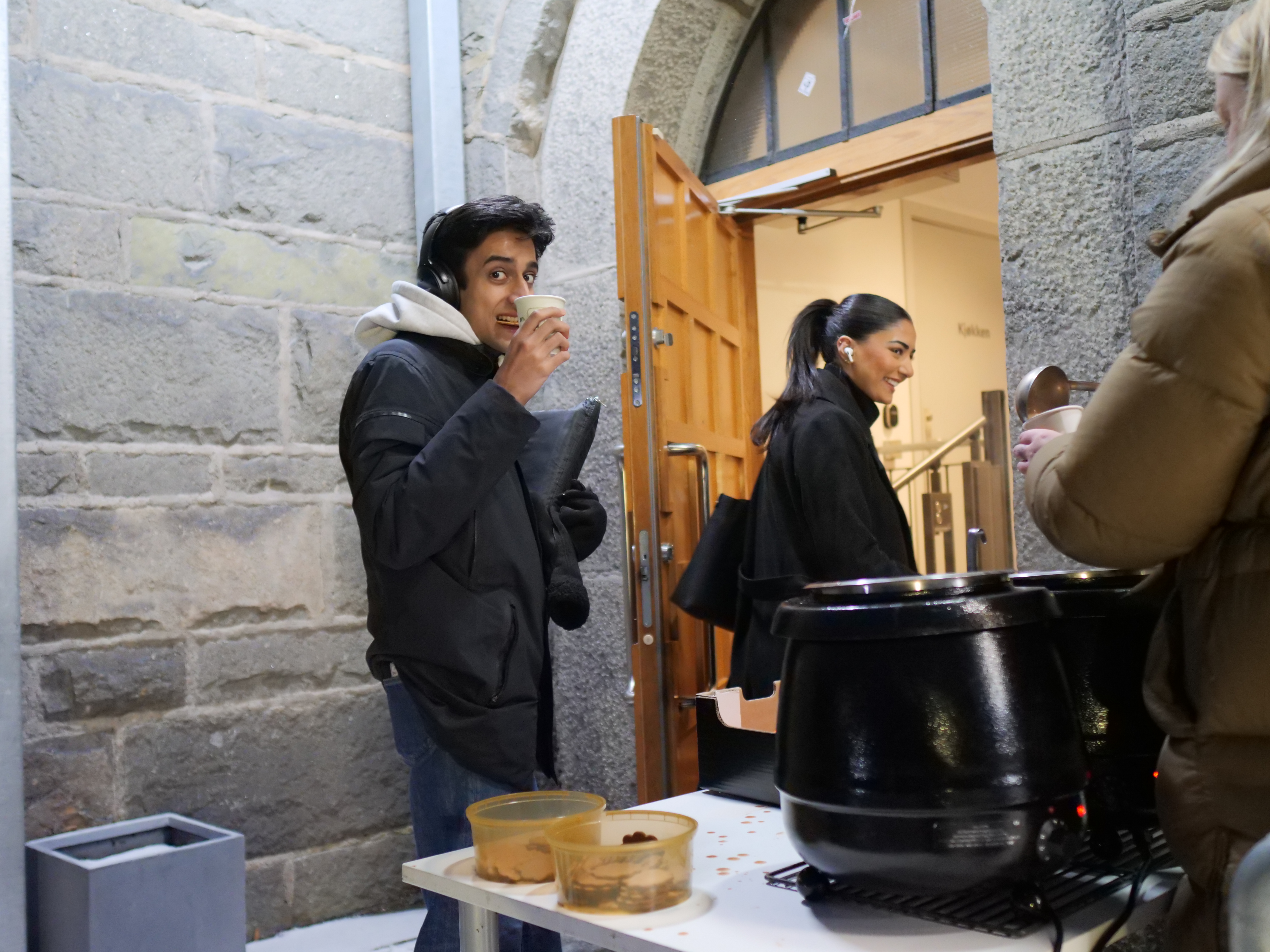 en person som står ved siden av en person som sitter ved et bord