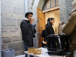 en person som står ved siden av en person som sitter ved et bord