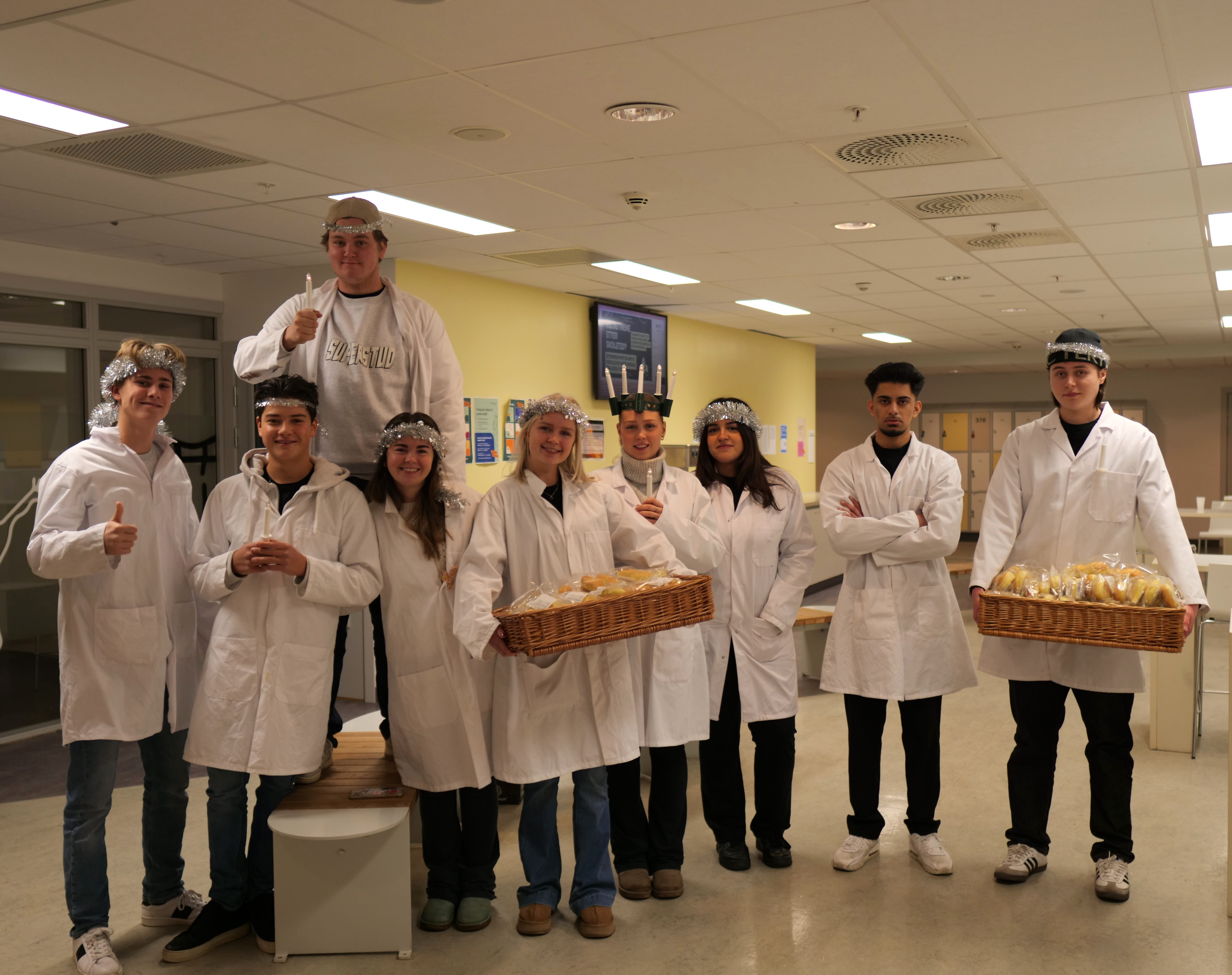 En gruppe mennesker iført hvite frakker og holder et brett med mat