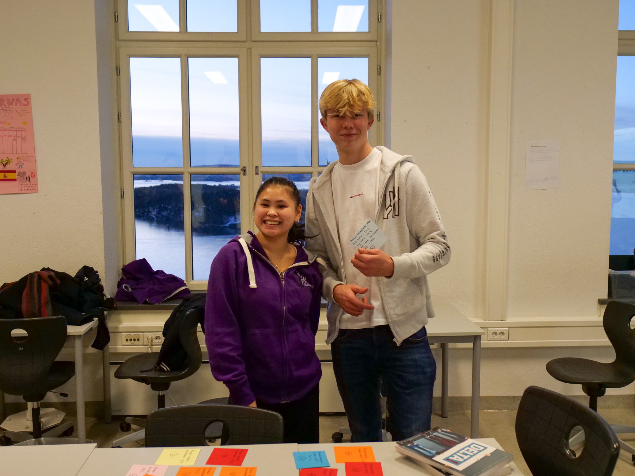 en person og en person som står i et rom med vindu og stoler