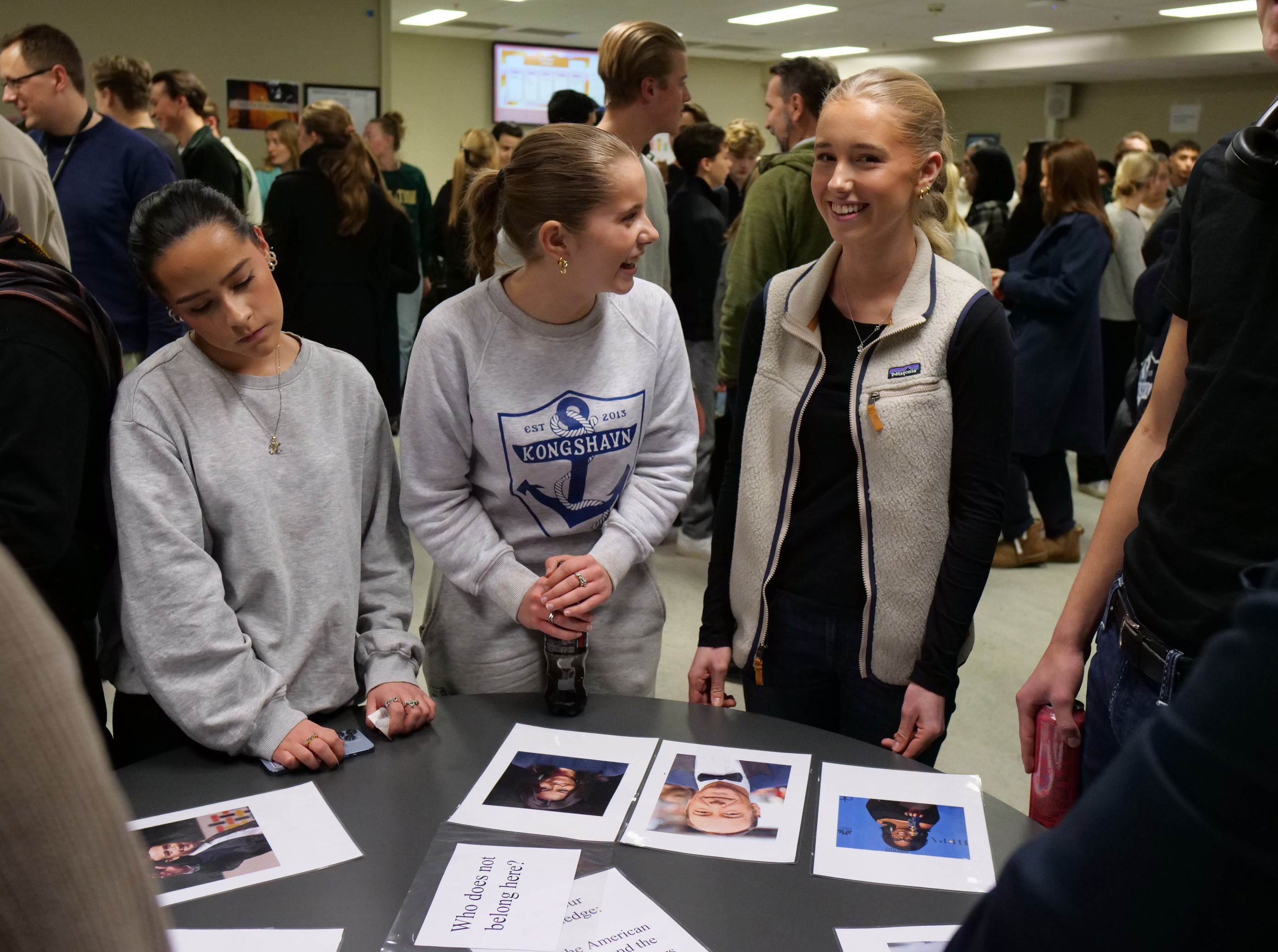 en gruppe mennesker som står rundt et bord med en bok og et bilde på en gruppe mennesker som står rundt et bord med en bok og et bilde på