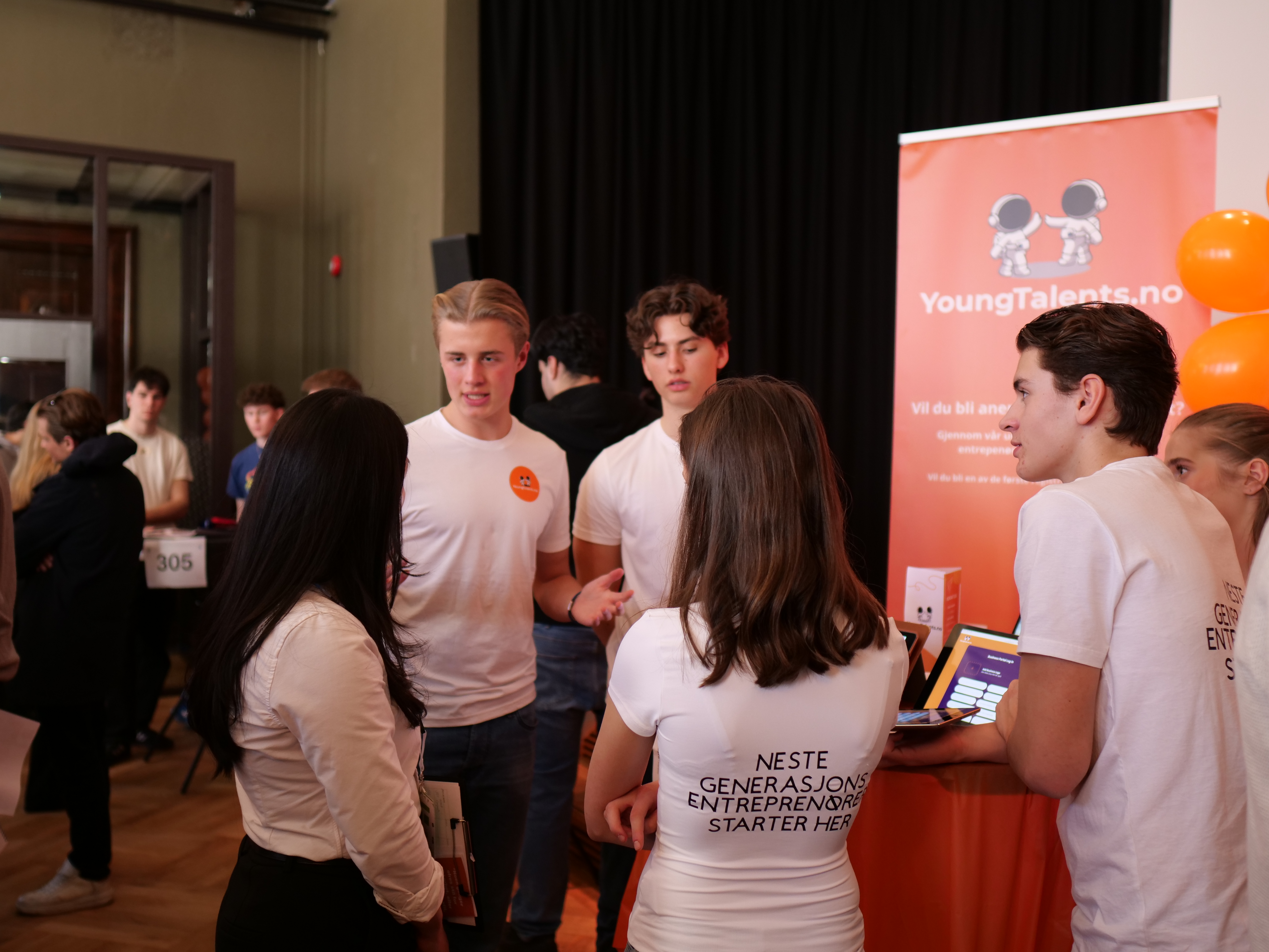 en gruppe mennesker som står i et rom