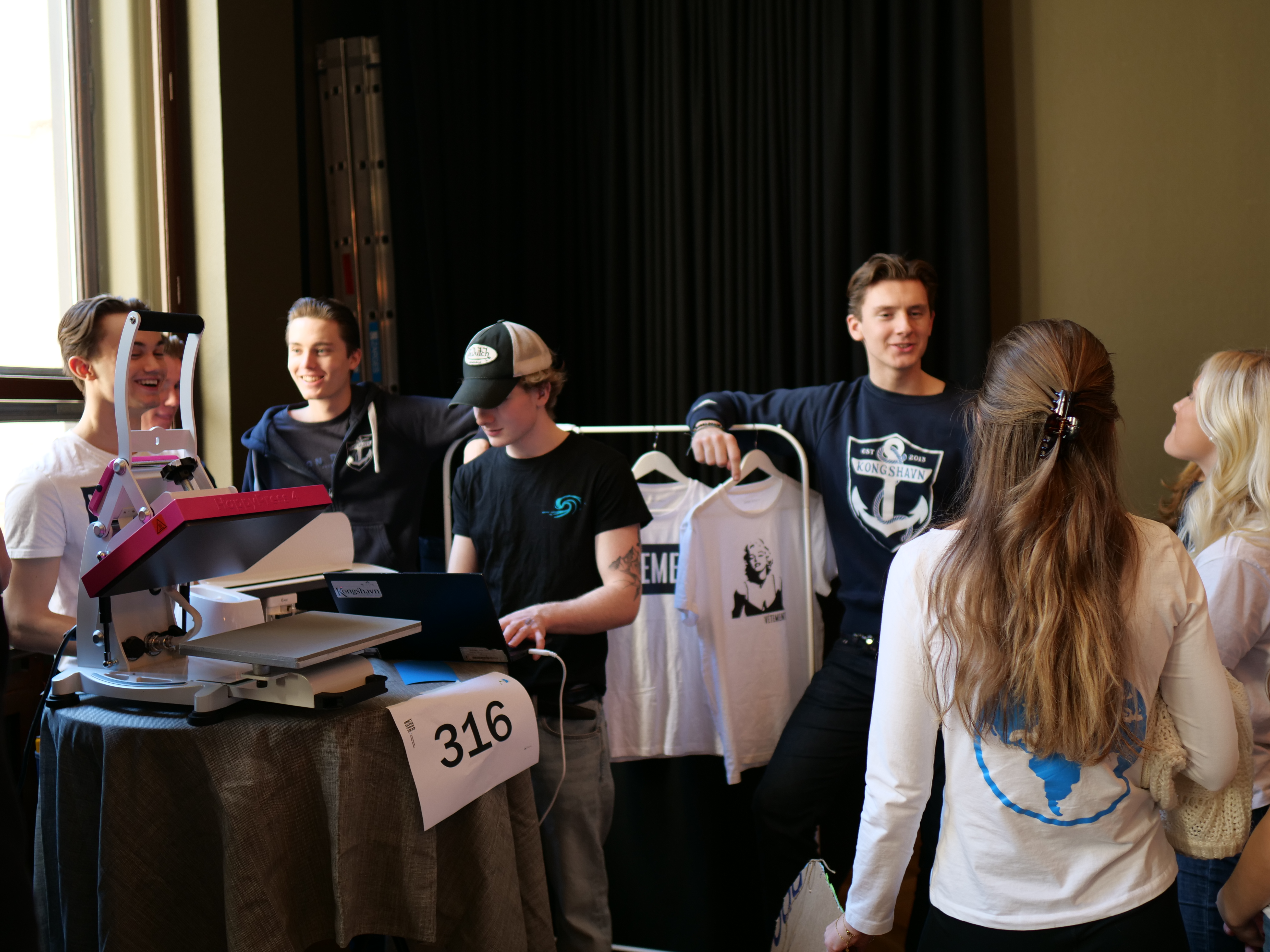 En gruppe mennesker som står rundt et bord med bærbare datamaskiner