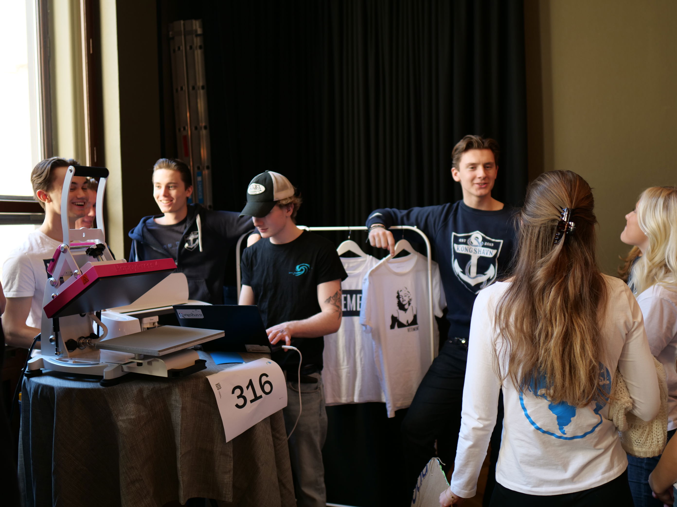 En gruppe mennesker som står rundt et bord med bærbare datamaskiner En gruppe mennesker som står rundt et bord med bærbare datamaskiner