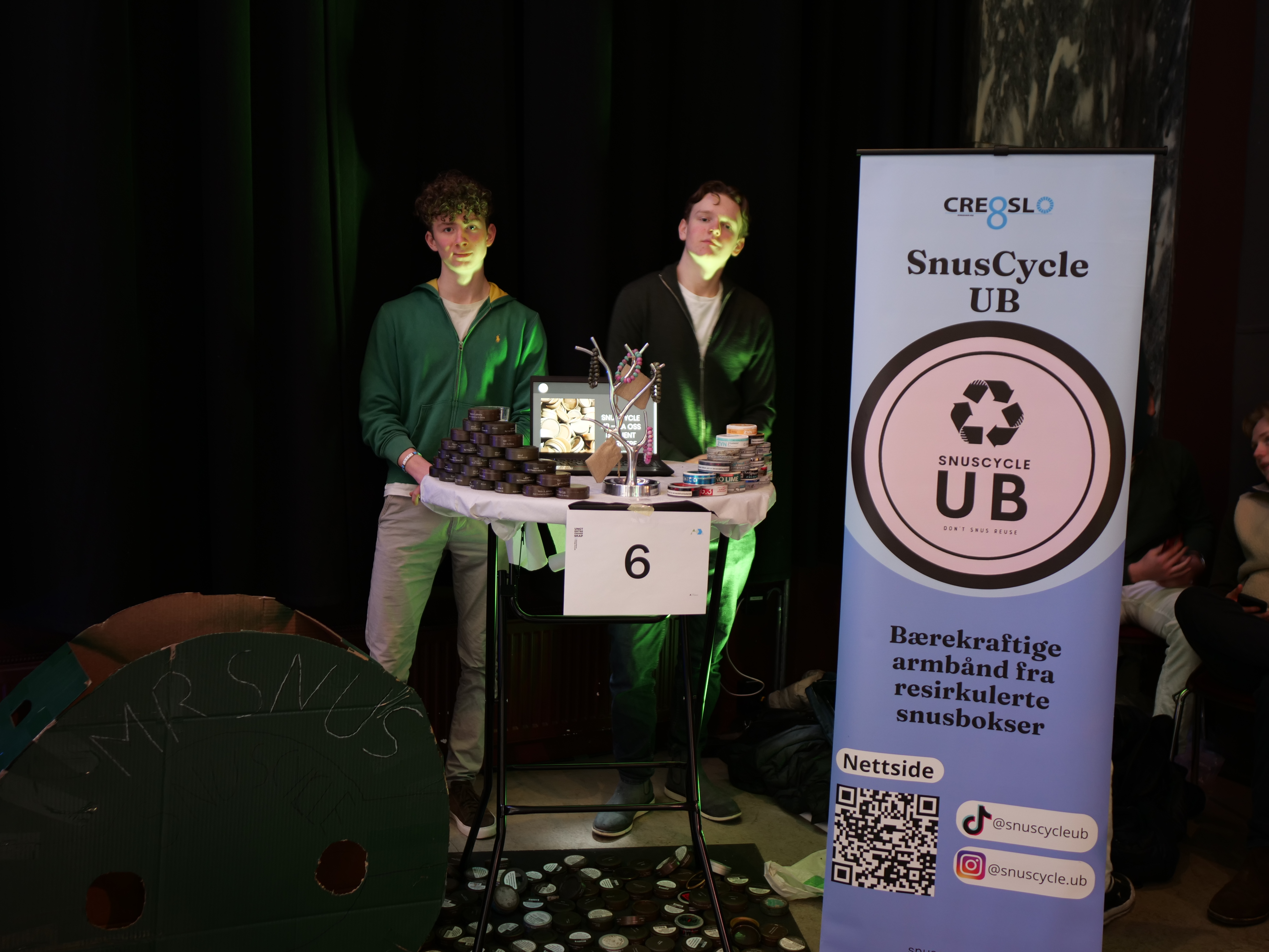 et par menn som står på et podium med mikrofon og et skilt