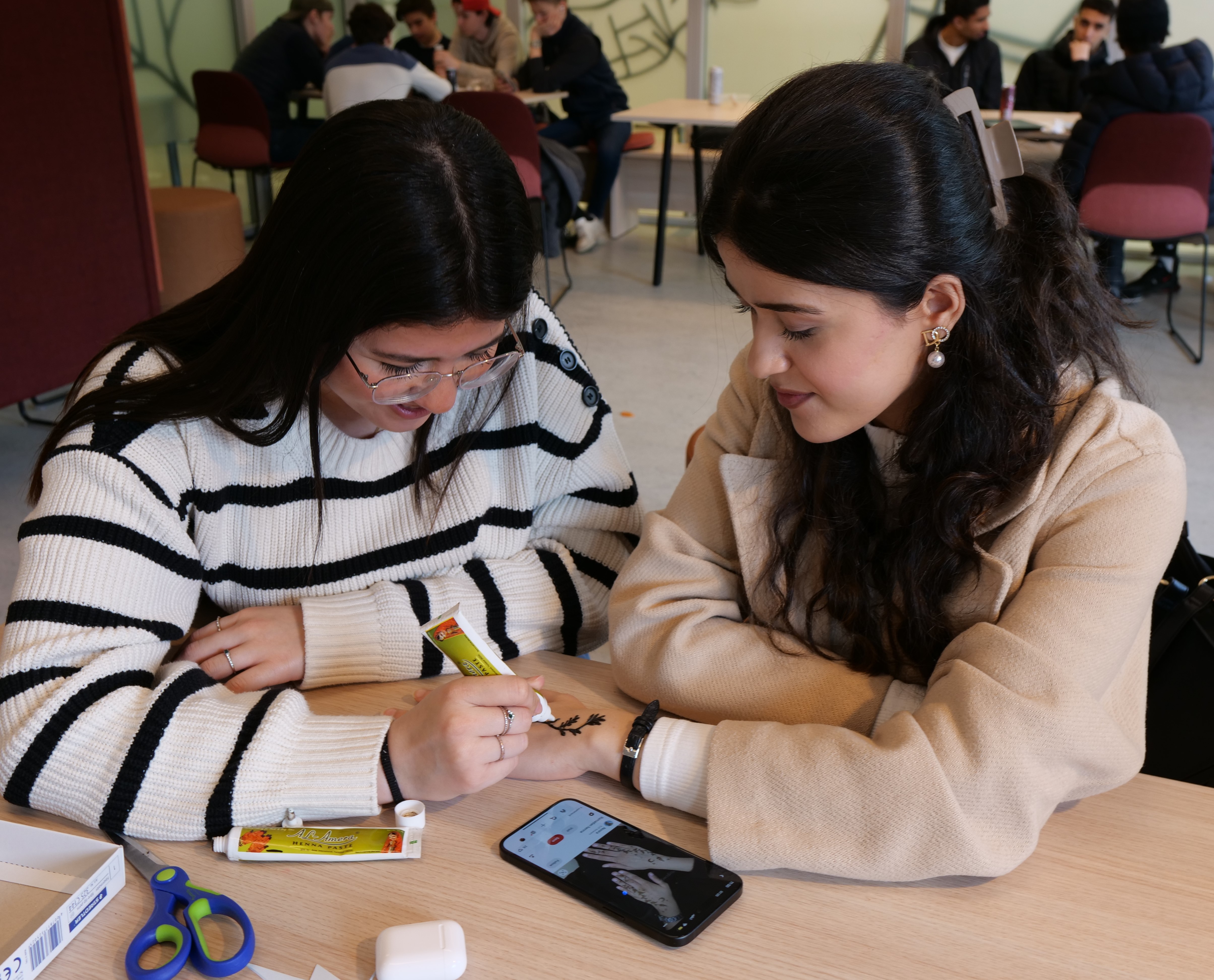 et par personr som ser på en mobiltelefon