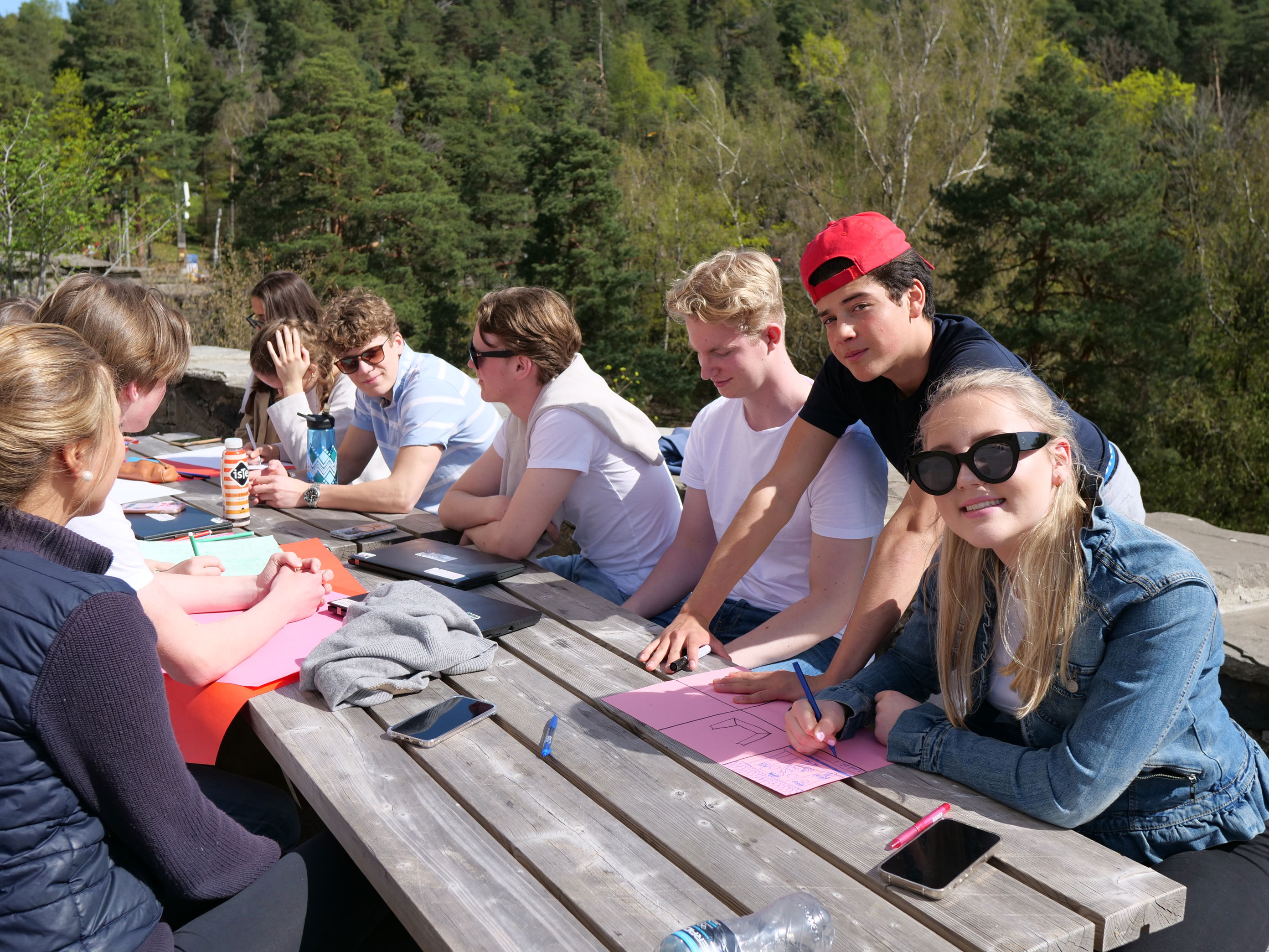 en gruppe mennesker som sitter ved et piknikbord en gruppe mennesker som sitter ved et piknikbord
