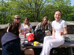 en gruppe personr som sitter ved et bord utenfor
