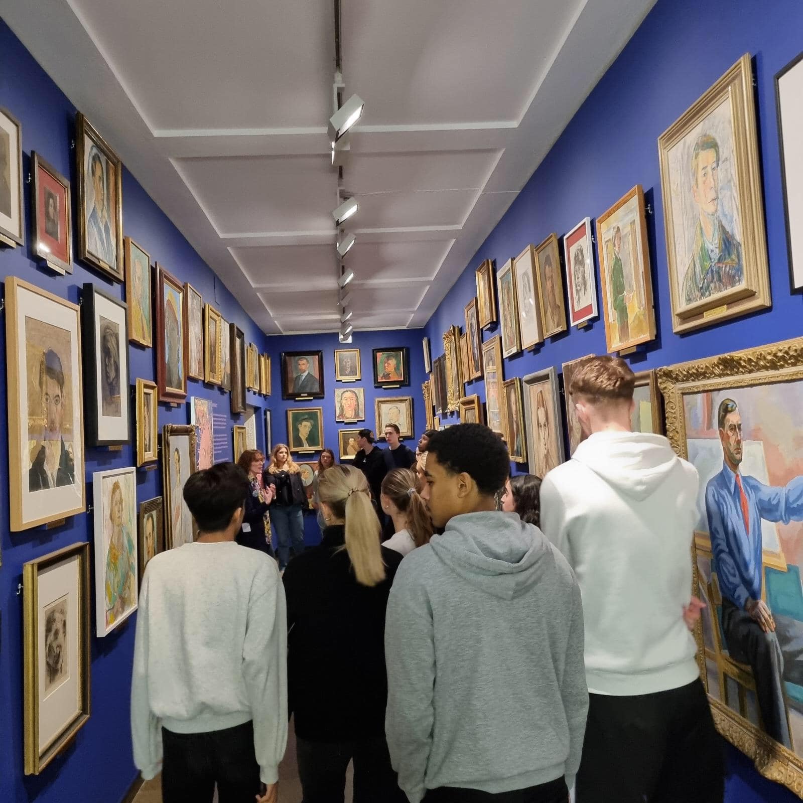 En gruppe mennesker som ser på kunst på veggen