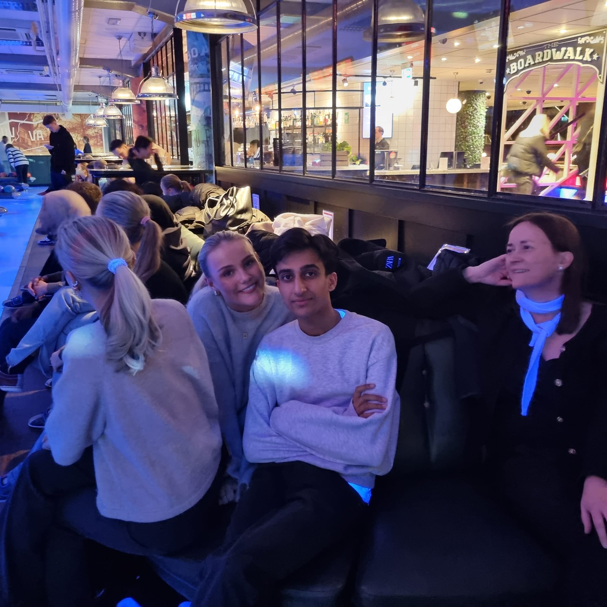 En gruppe mennesker som sitter på en benk og poserer for kameraet