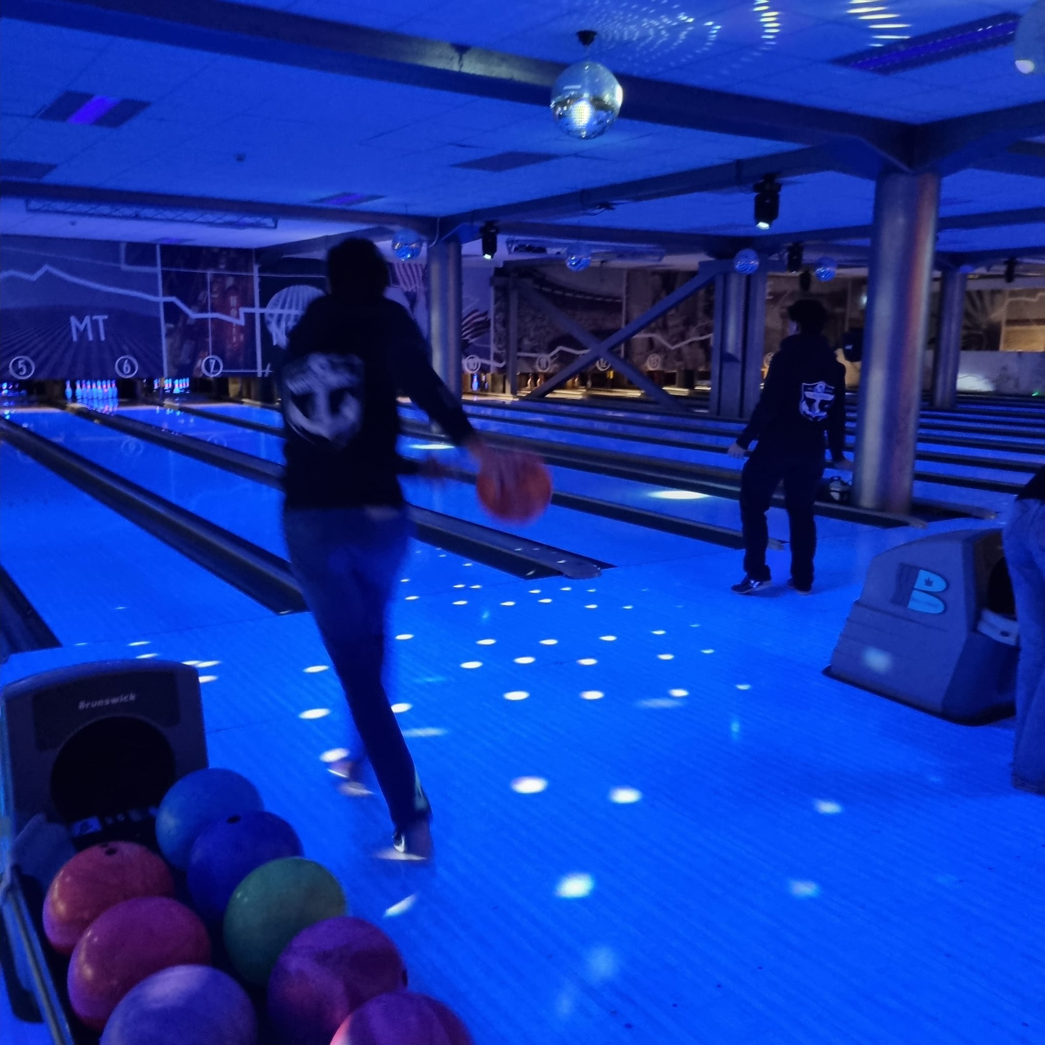 en person som holder en ball i en bowlinghall