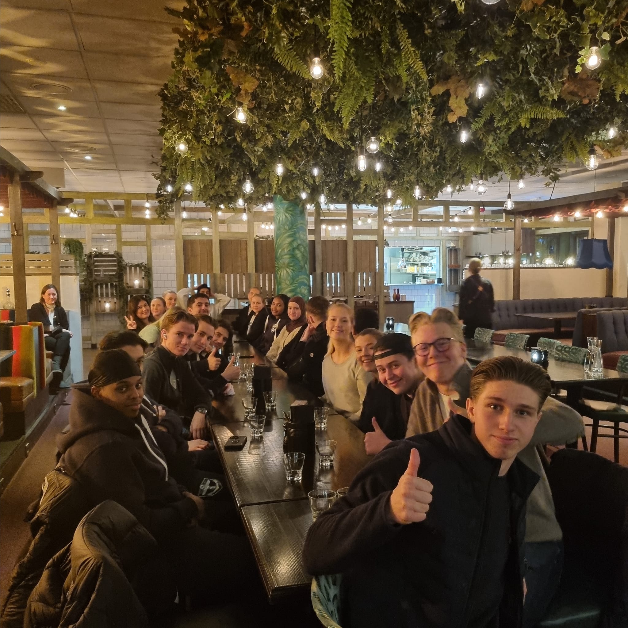 en gruppe mennesker som sitter ved bordene