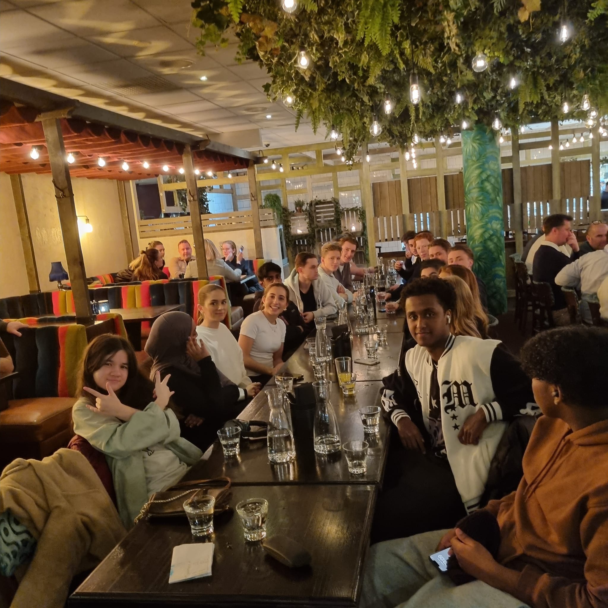 en stor gruppe mennesker som sitter ved bordene