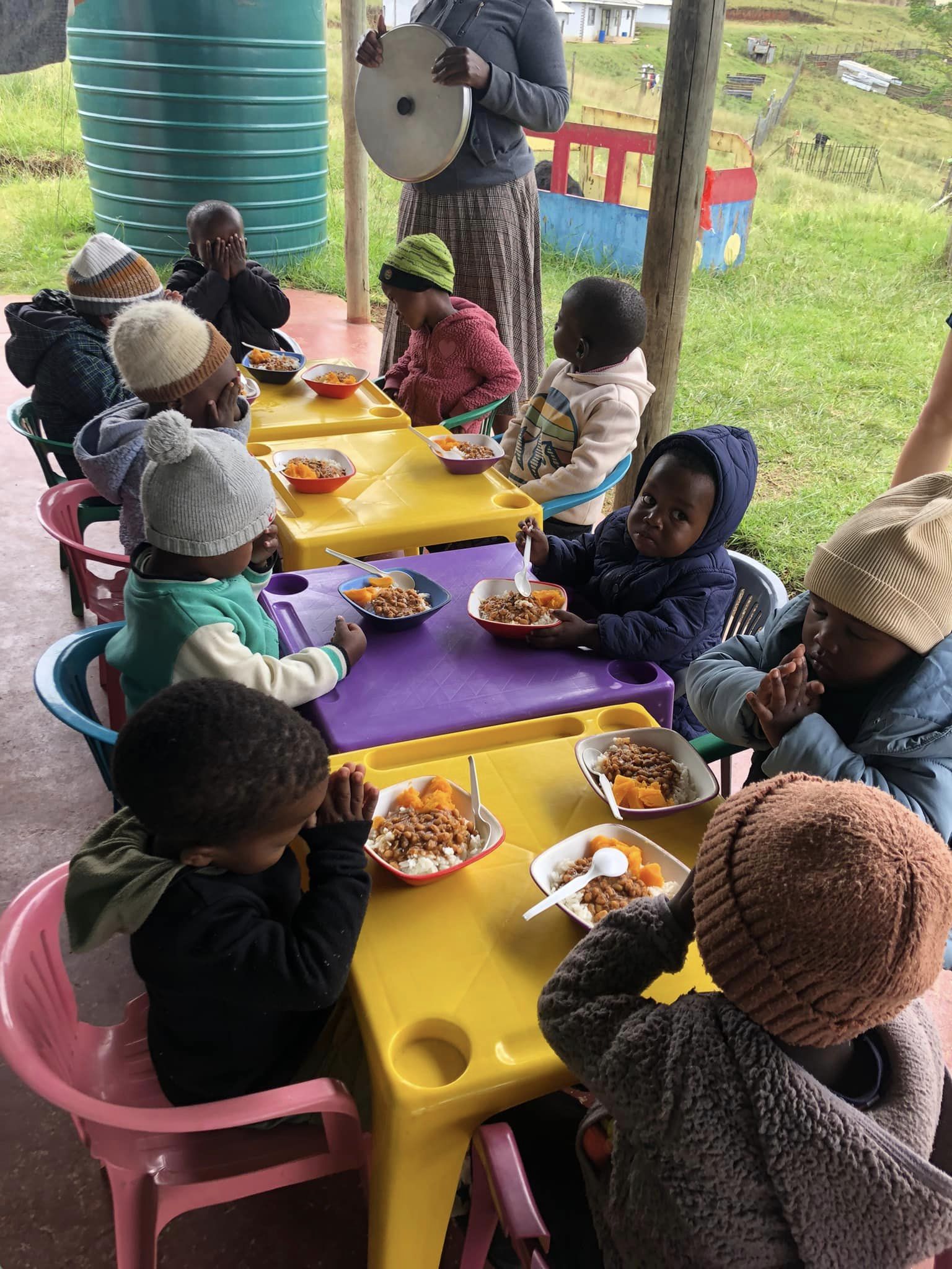 en gruppe barn som spiser ved et piknikbord