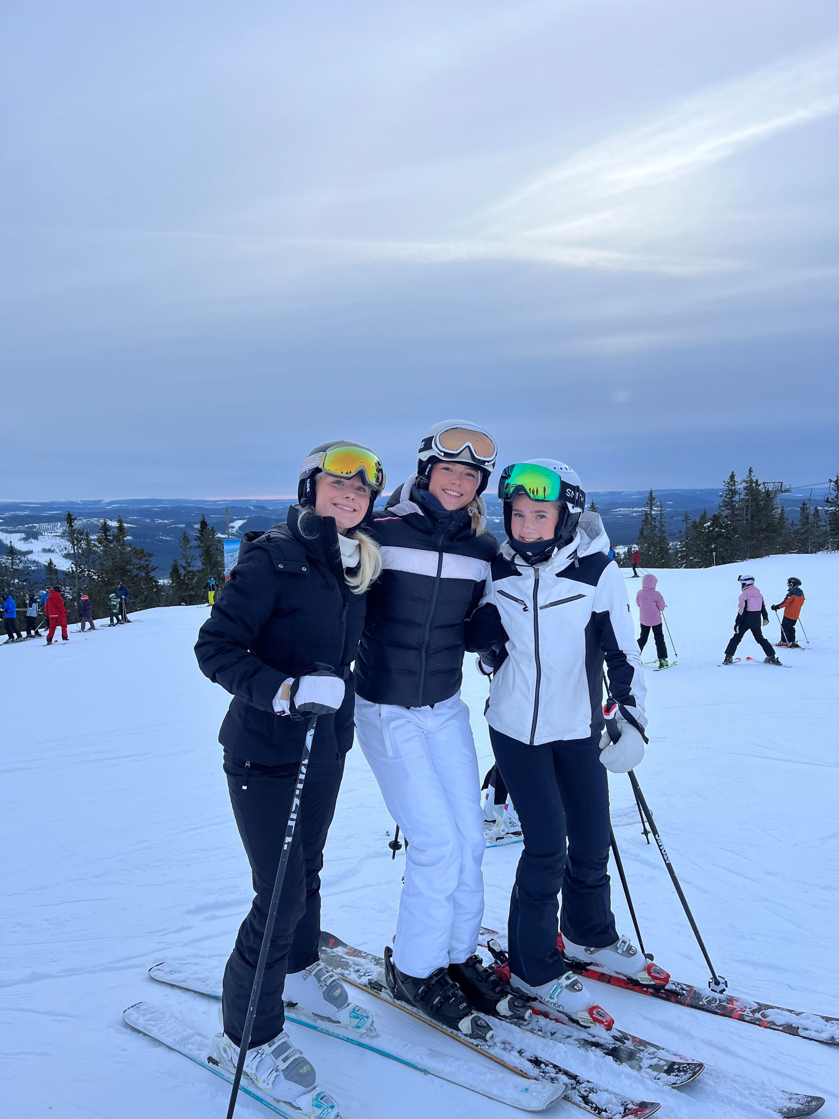 En gruppe mennesker poserer på snøski