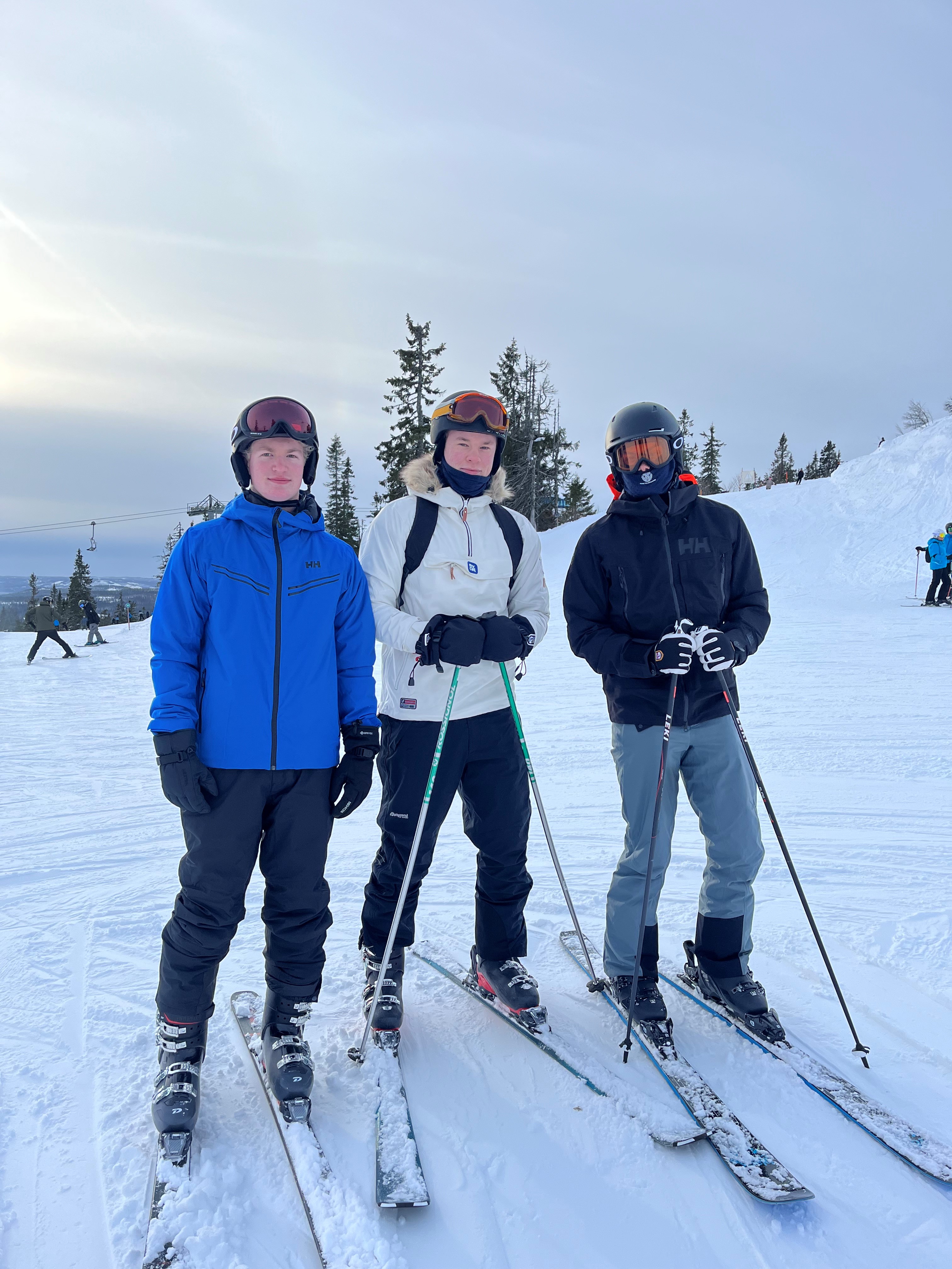 En gruppe mennesker poserer på snøski