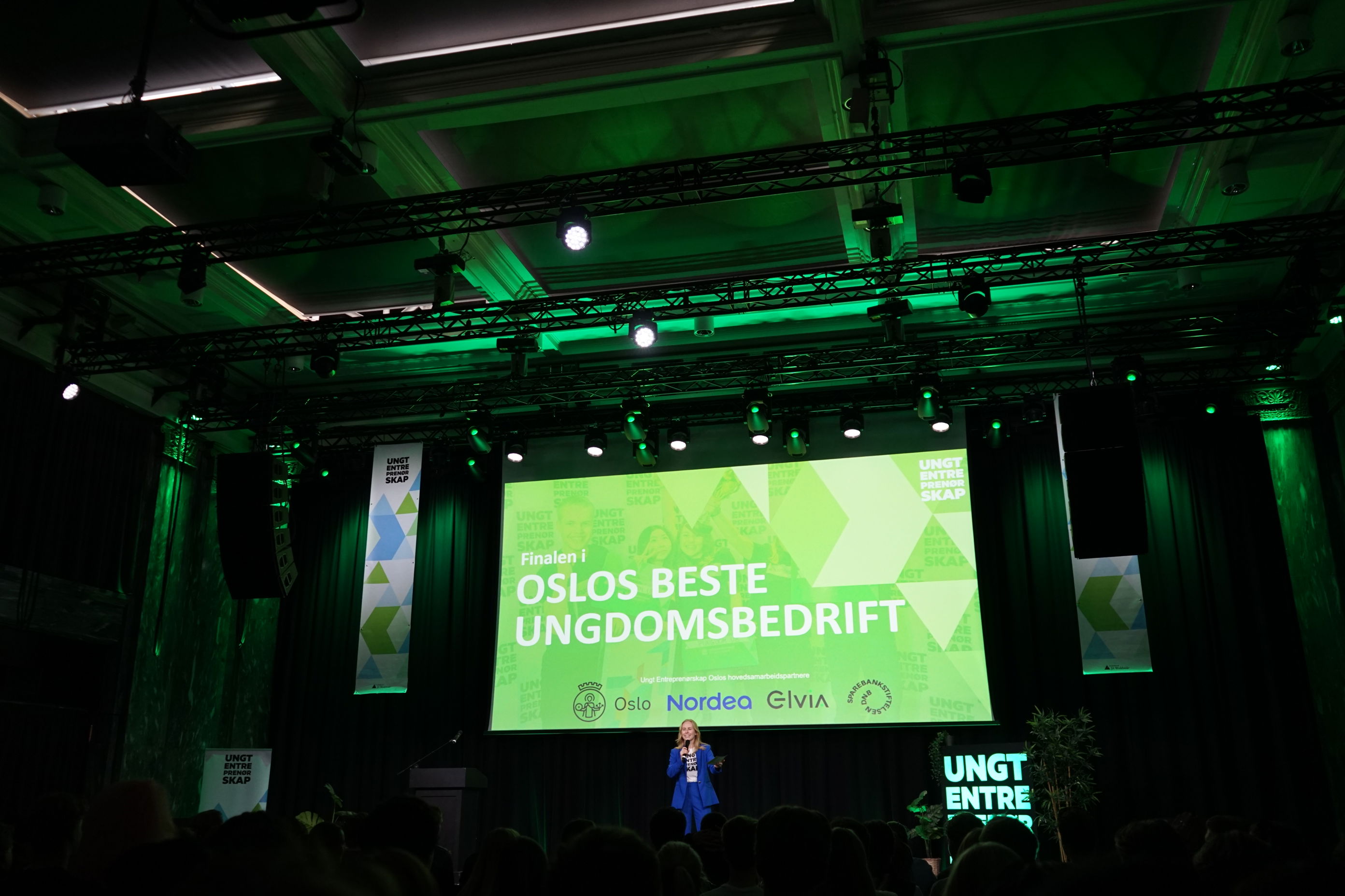 en person som står foran en stor skjerm med en folkemengde som ser på