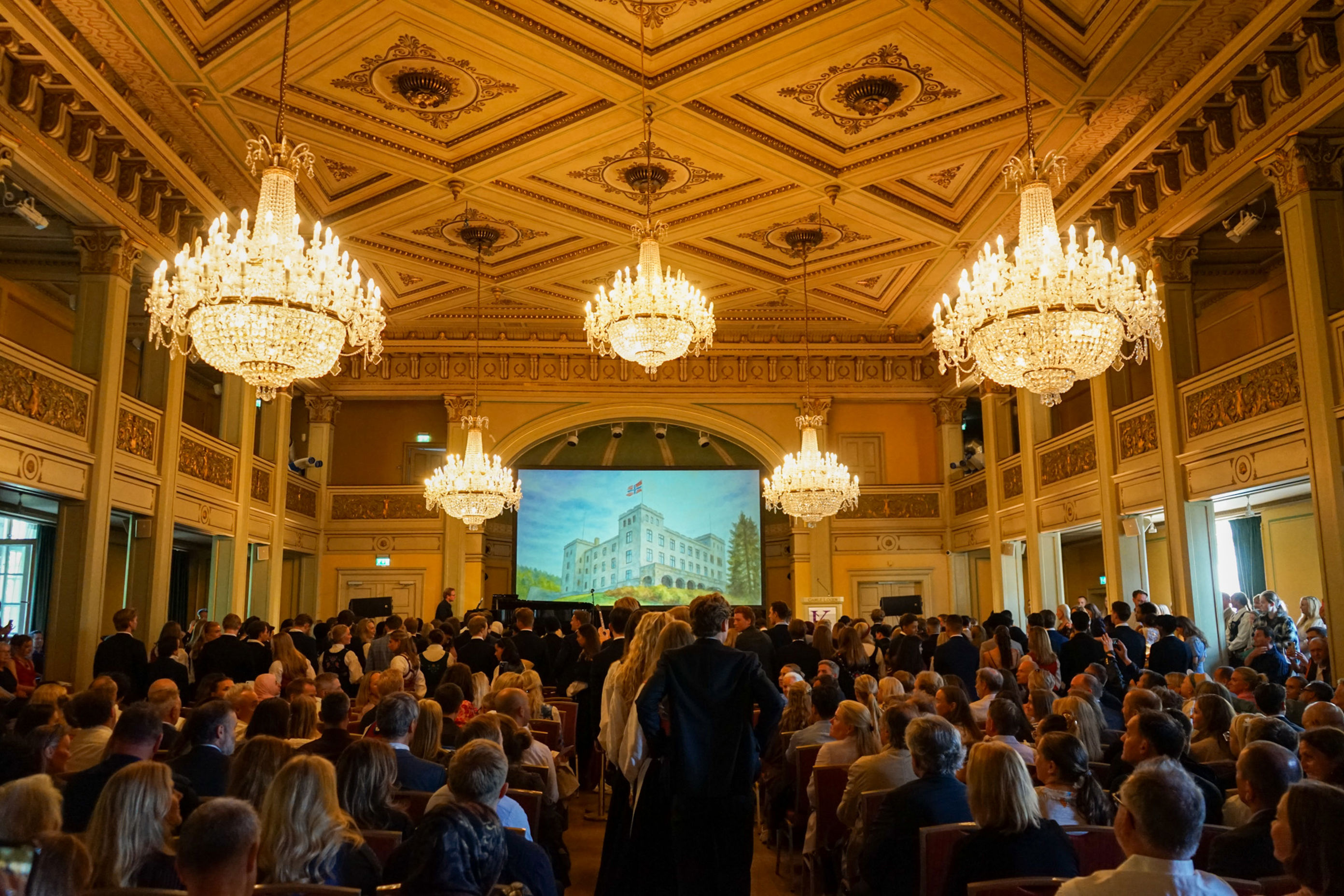 et stort rom med en scene og en gruppe mennesker i den