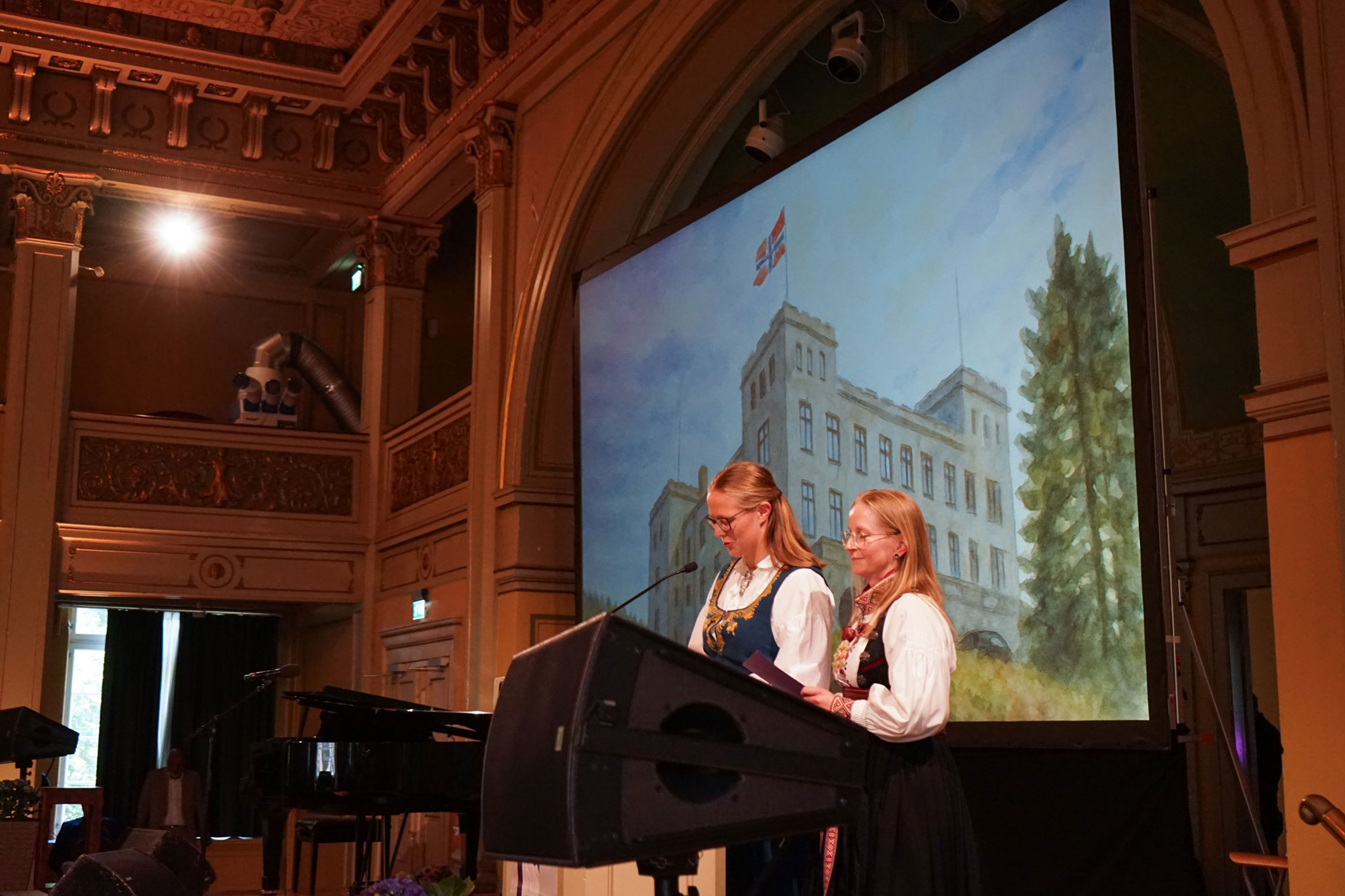 et par personr som står på et podium foran en storskjerm