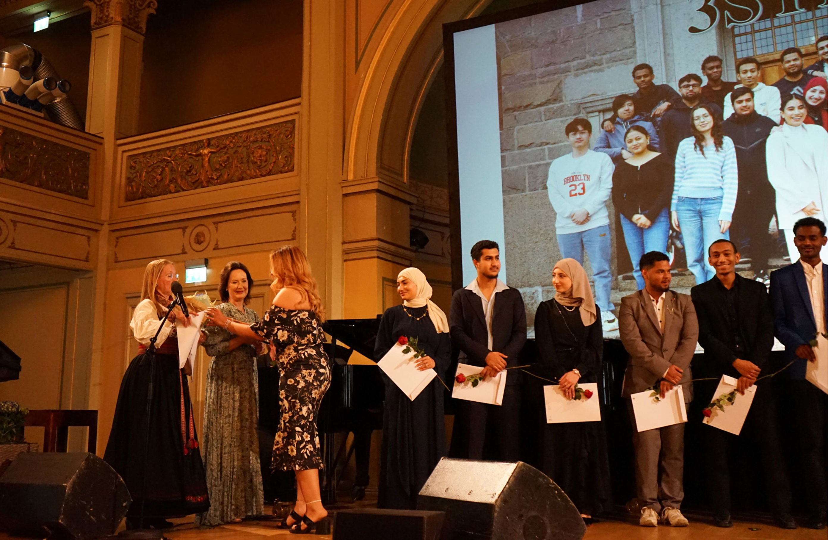 en gruppe mennesker som står foran en scene