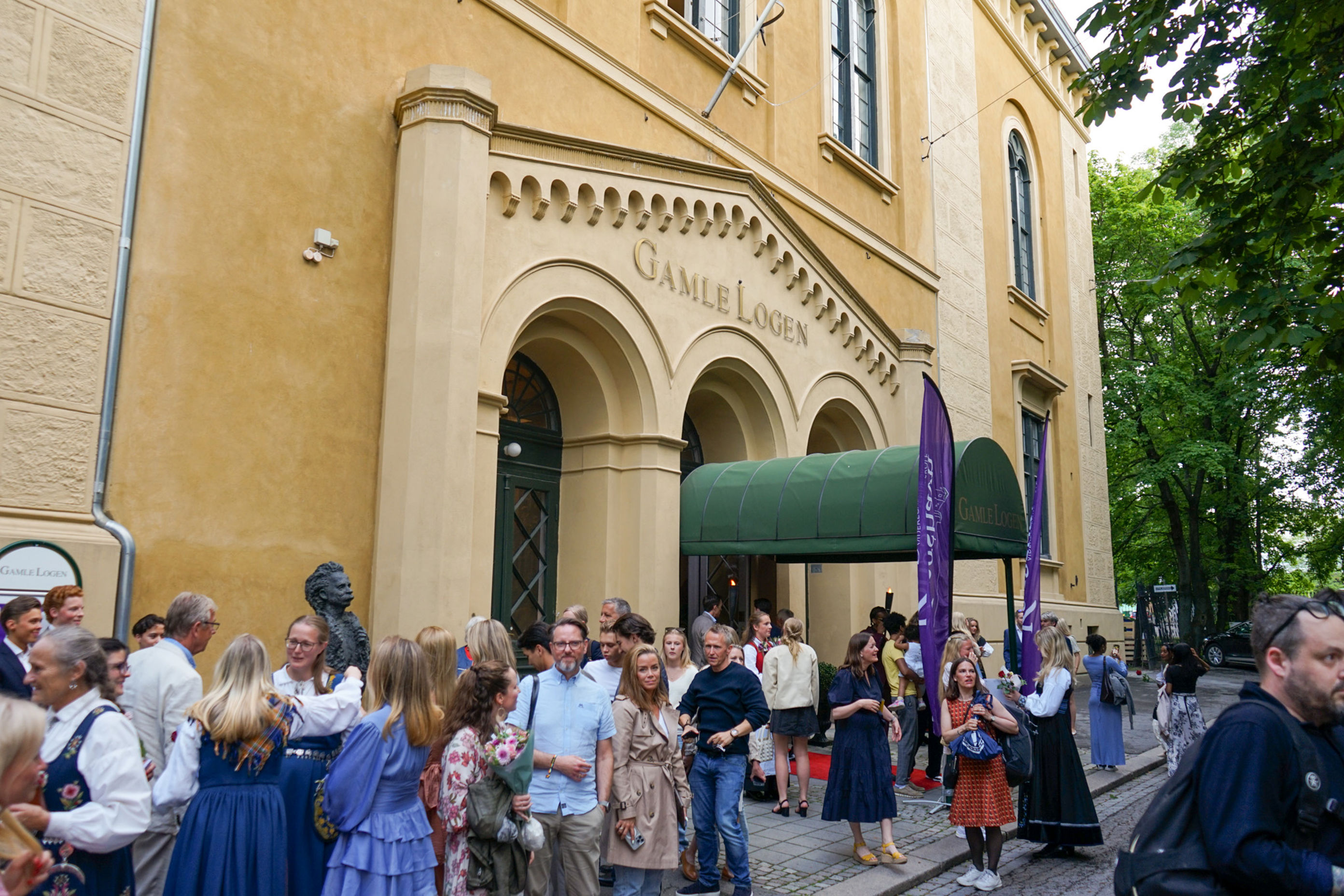 en gruppe mennesker som står utenfor en bygning