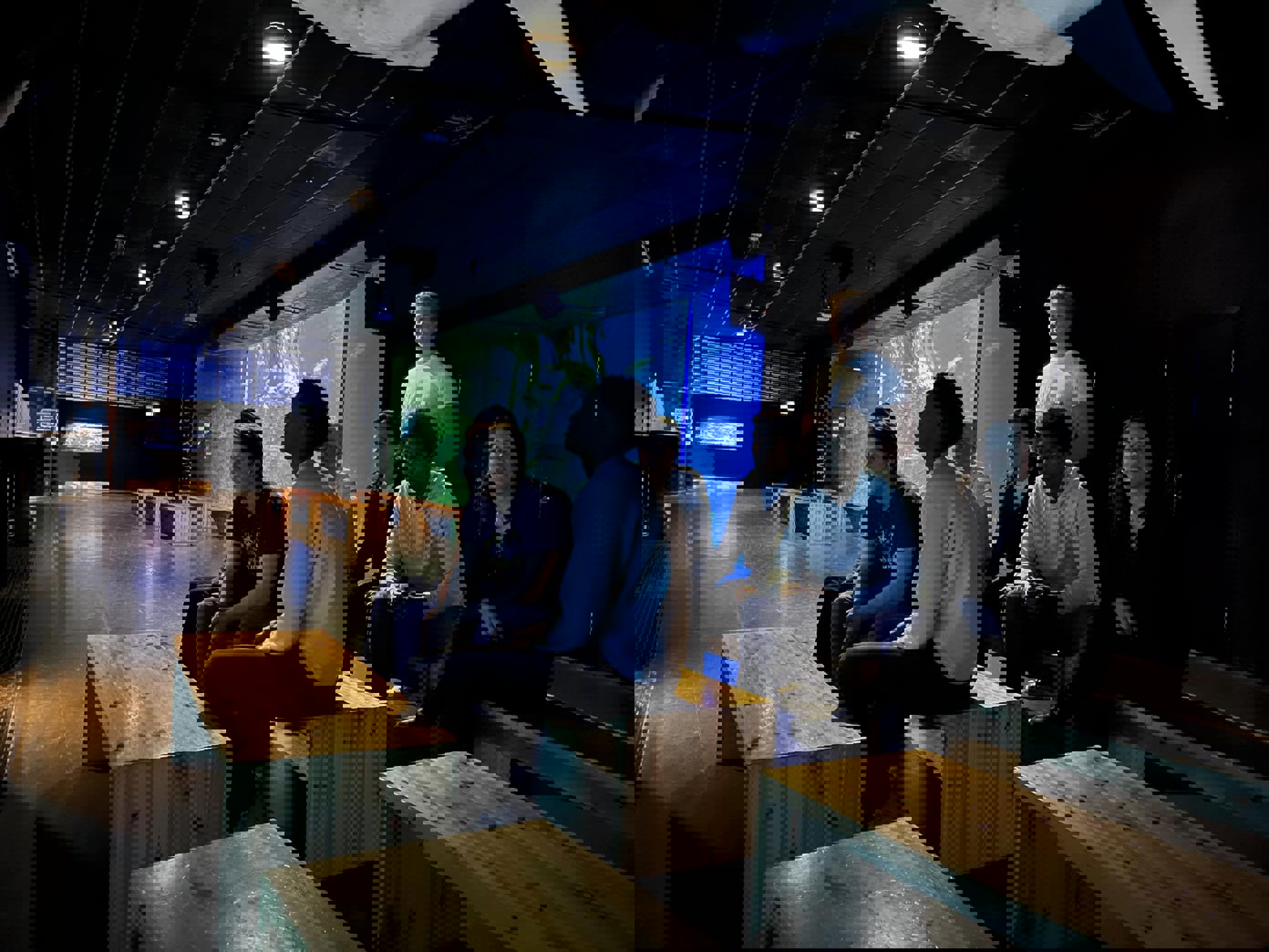 en gruppe mennesker som sitter ved skrivebord i et rom en gruppe mennesker som sitter ved skrivebord i et rom