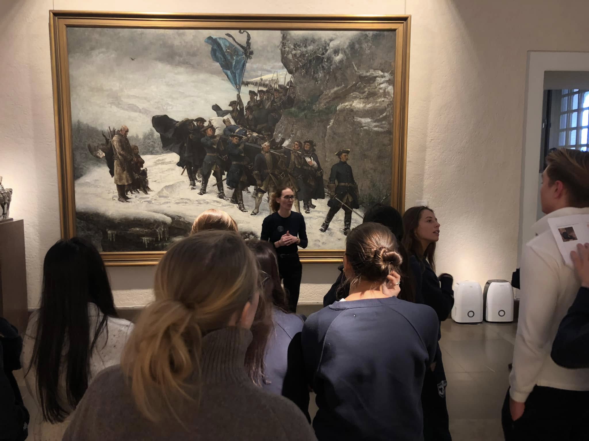 En gruppe mennesker som ser på et maleri på en vegg