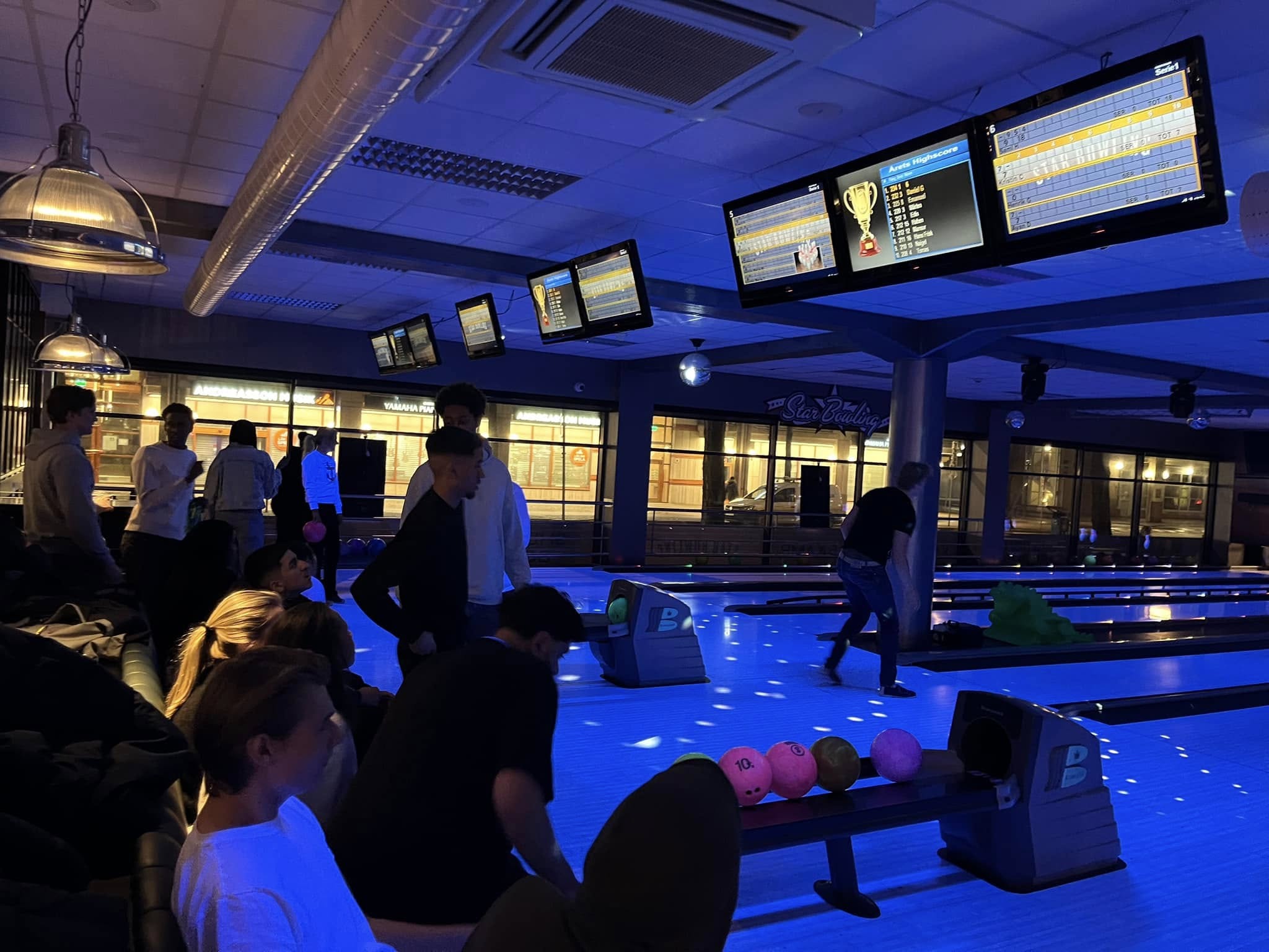 En gruppe mennesker i en bowlinghall