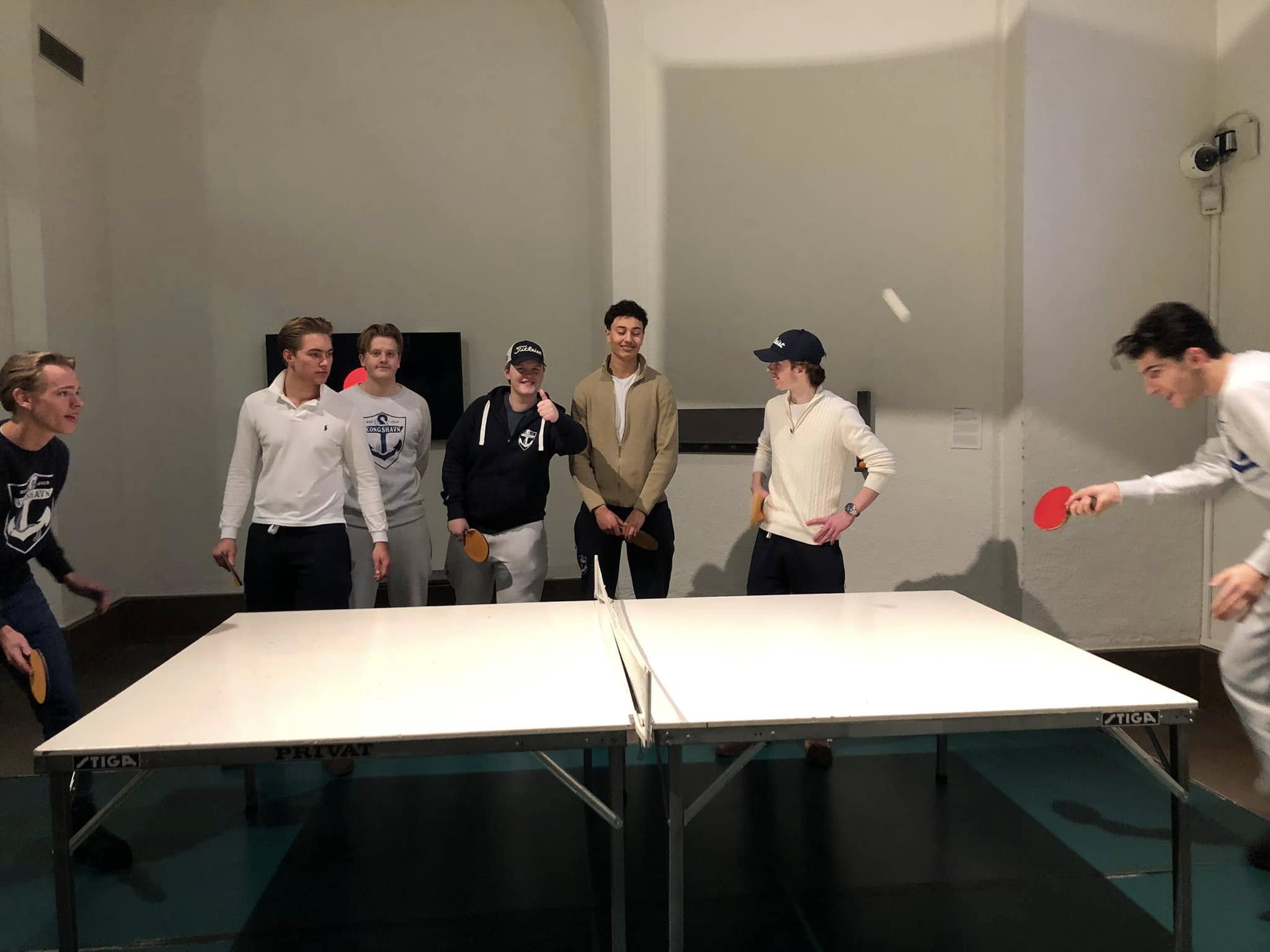 en gruppe mennesker som står rundt et bord med en hvit duk