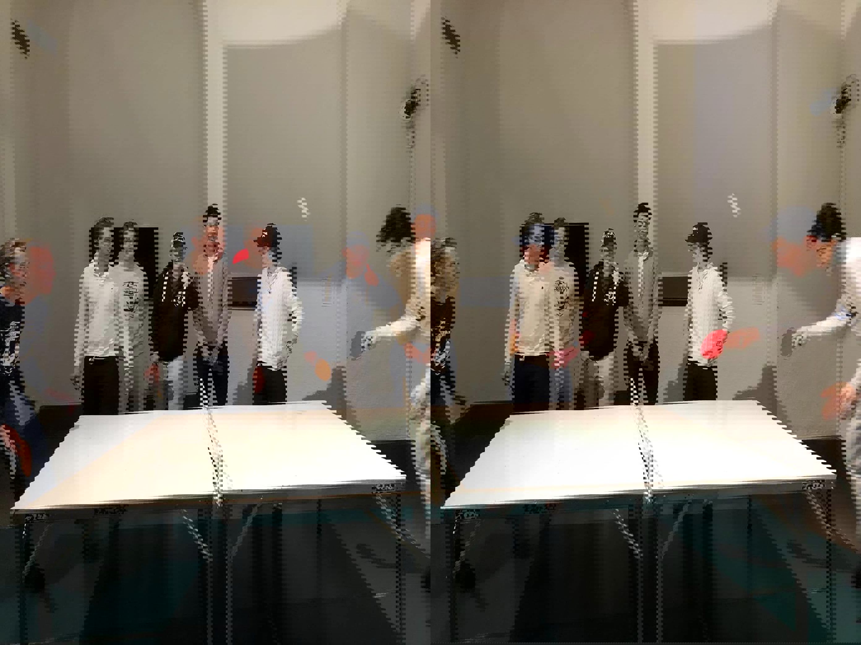 en gruppe mennesker som står rundt et bord med en hvit duk en gruppe mennesker som står rundt et bord med en hvit duk