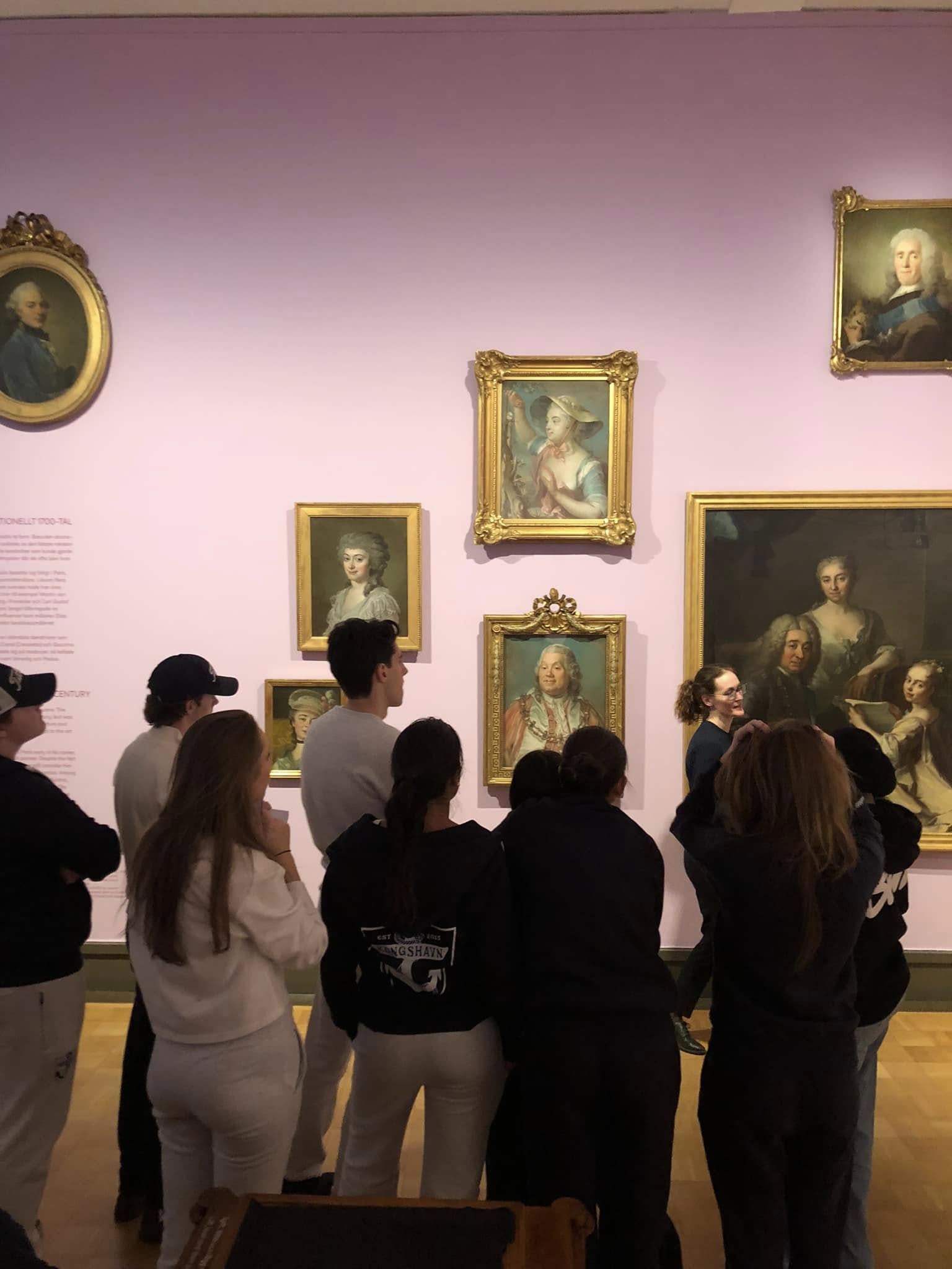 En gruppe mennesker som ser på kunst på veggen