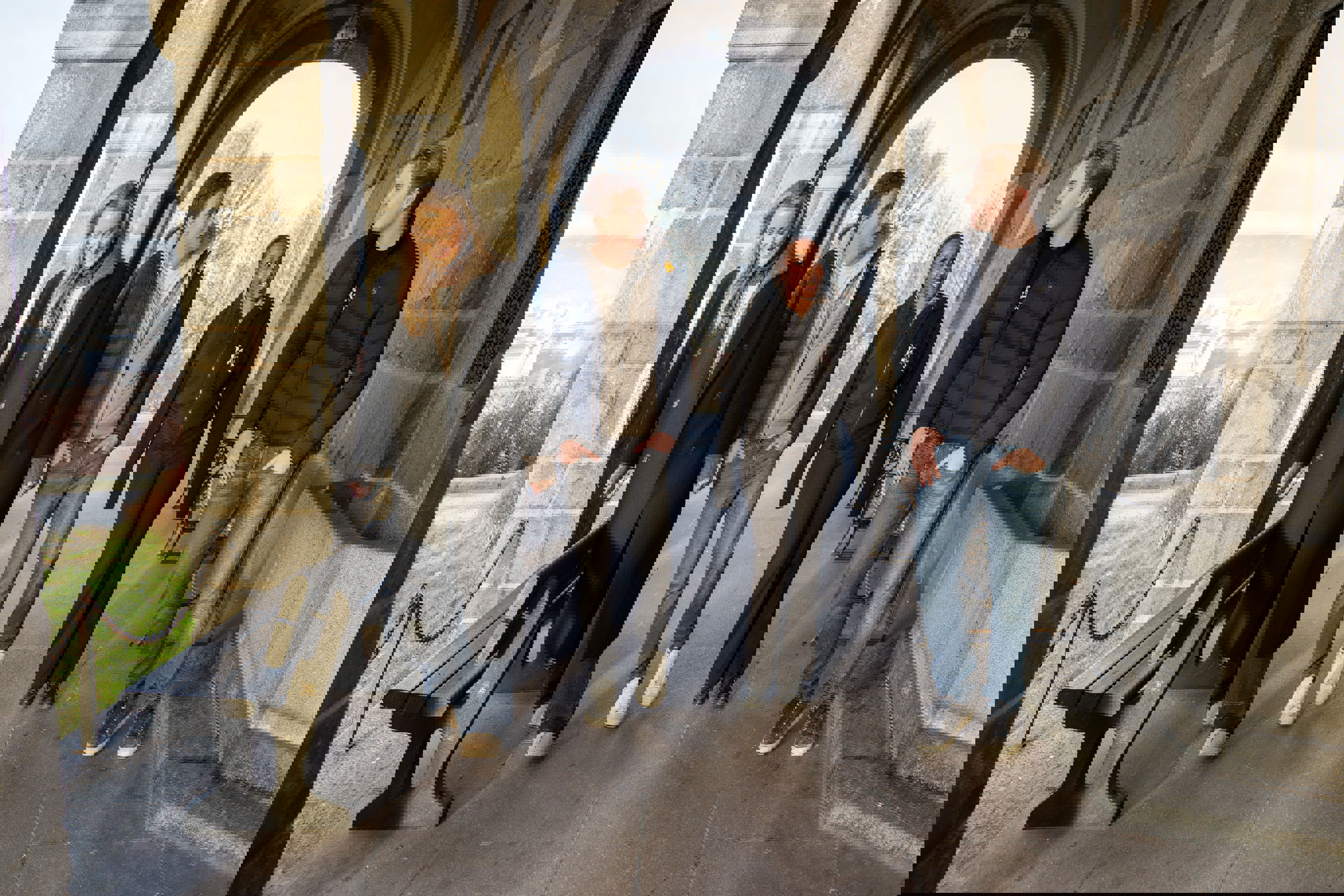 en gruppe mennesker som står foran en steinbue