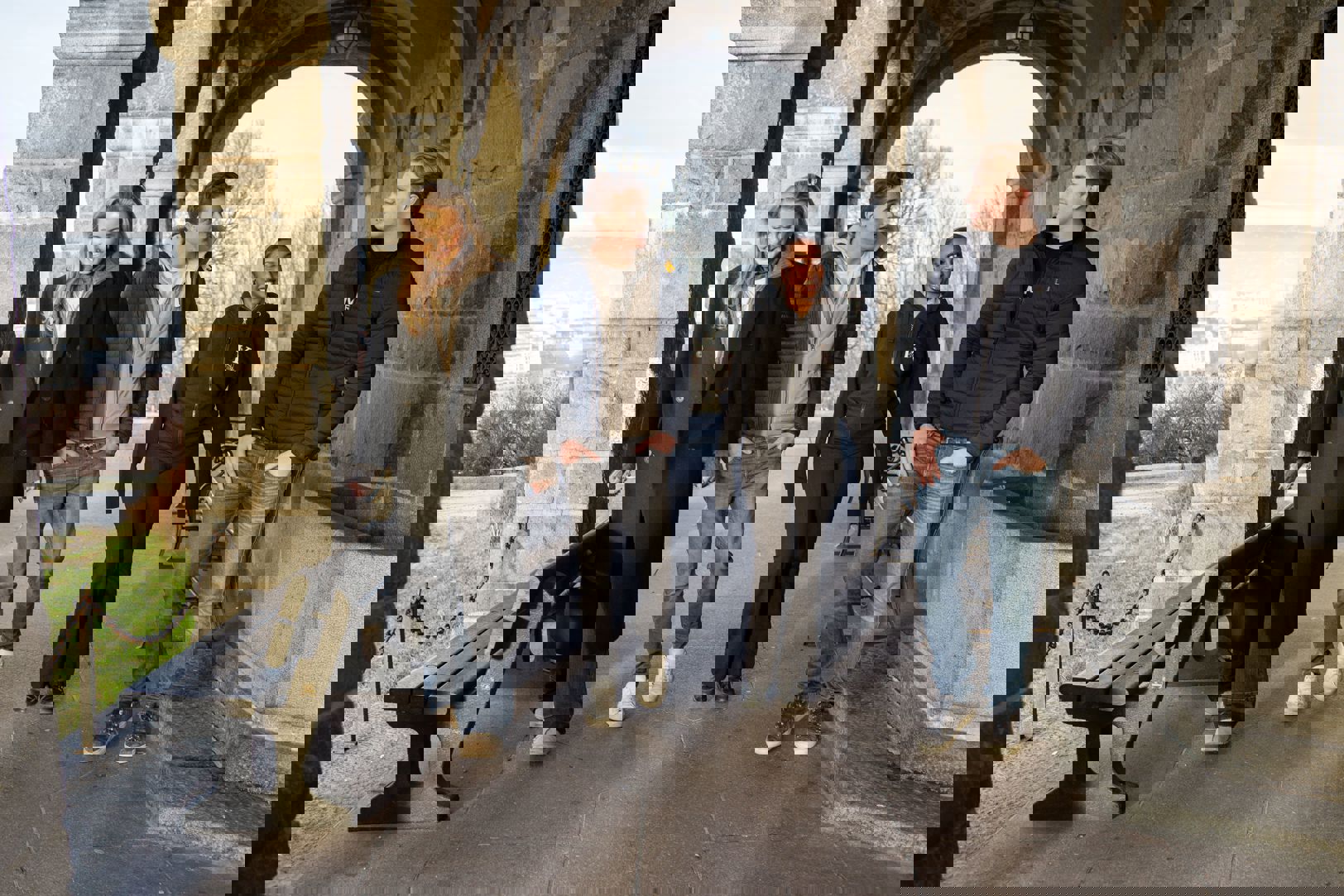 en gruppe mennesker som står foran en steinbue