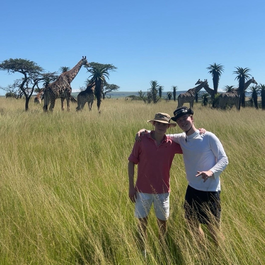 Et par menn står på en gresskledd eng