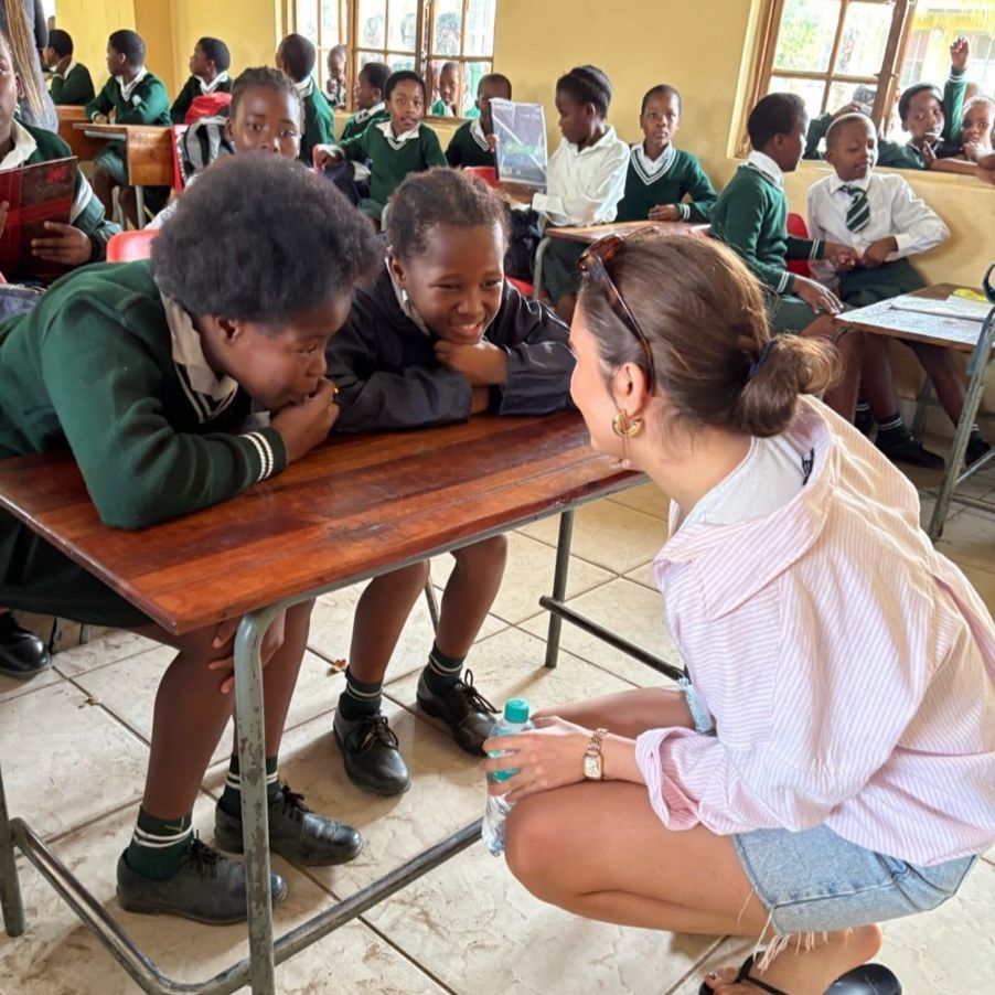 en person og en gruppe barn i et klasserom