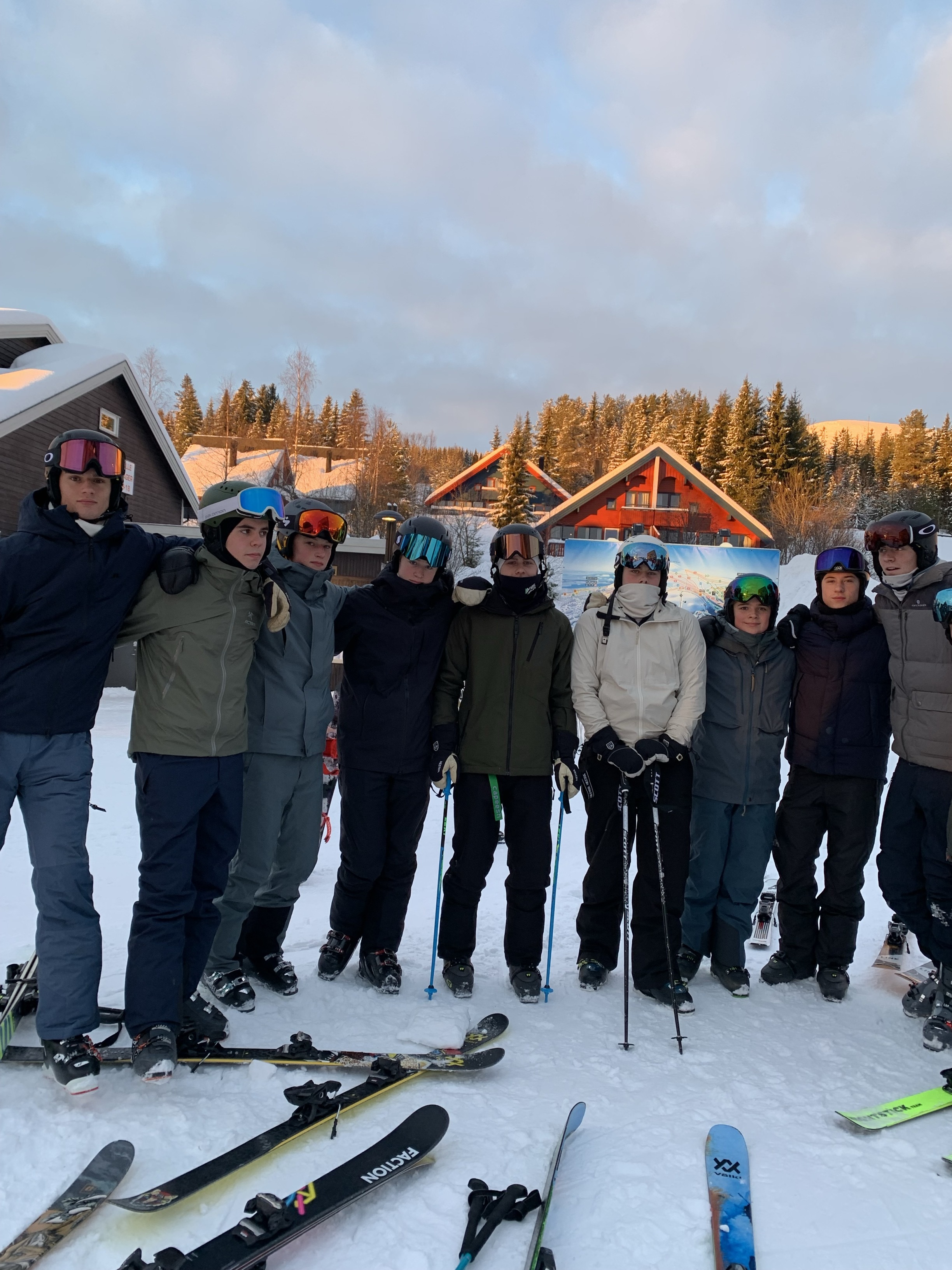 En gruppe mennesker poserer for et bilde på snøski