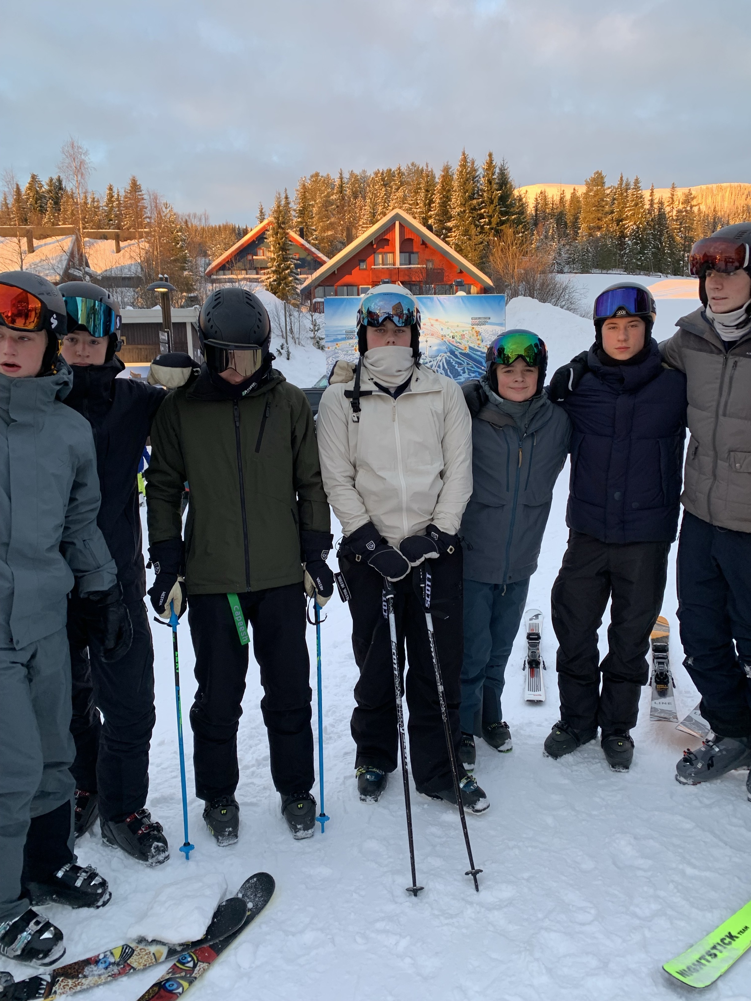 En gruppe mennesker poserer for et bilde på snøski