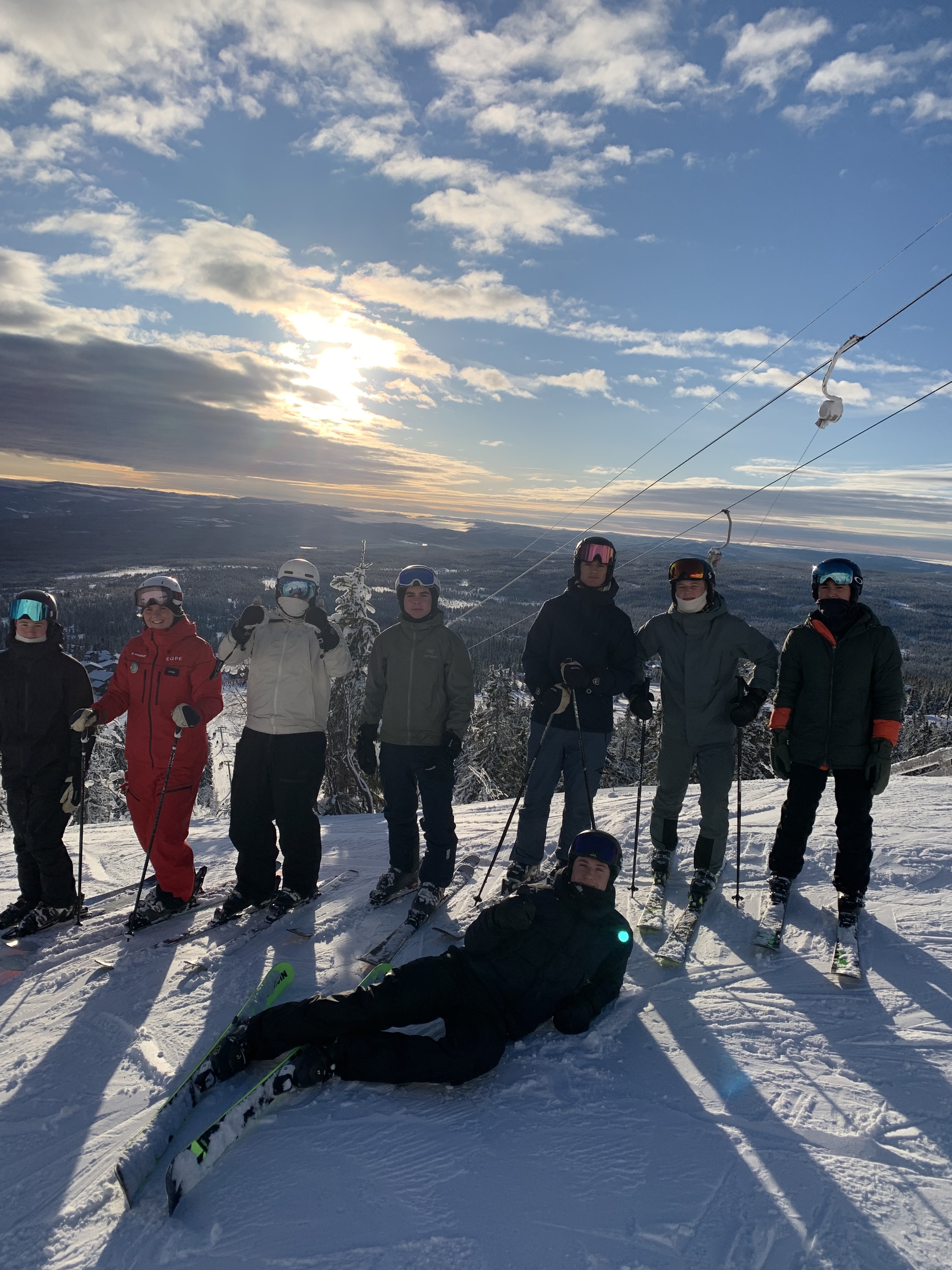 En gruppe mennesker som står på snøski og poserer for et bilde