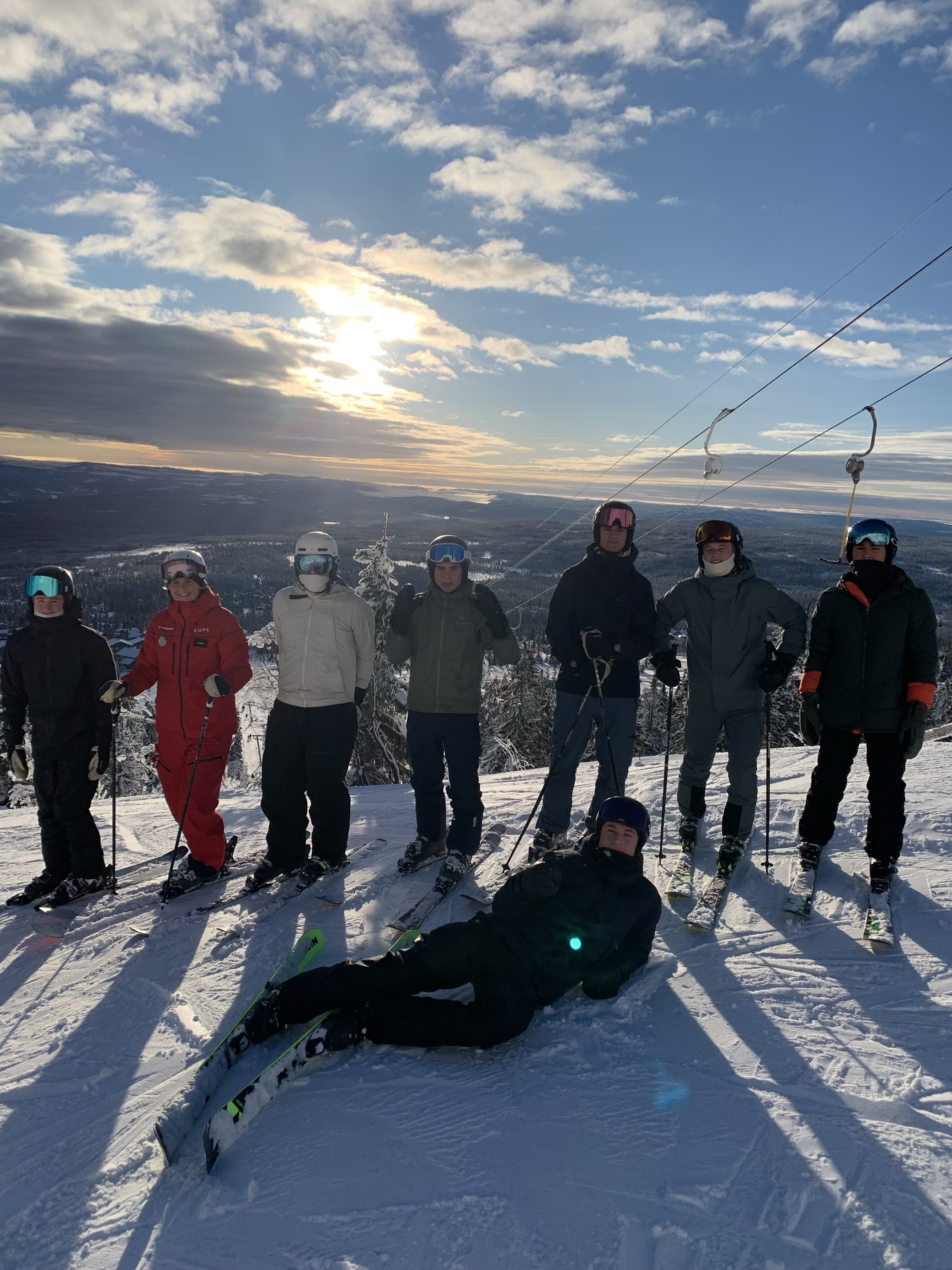 En gruppe mennesker som står på snøski og poserer for et bilde