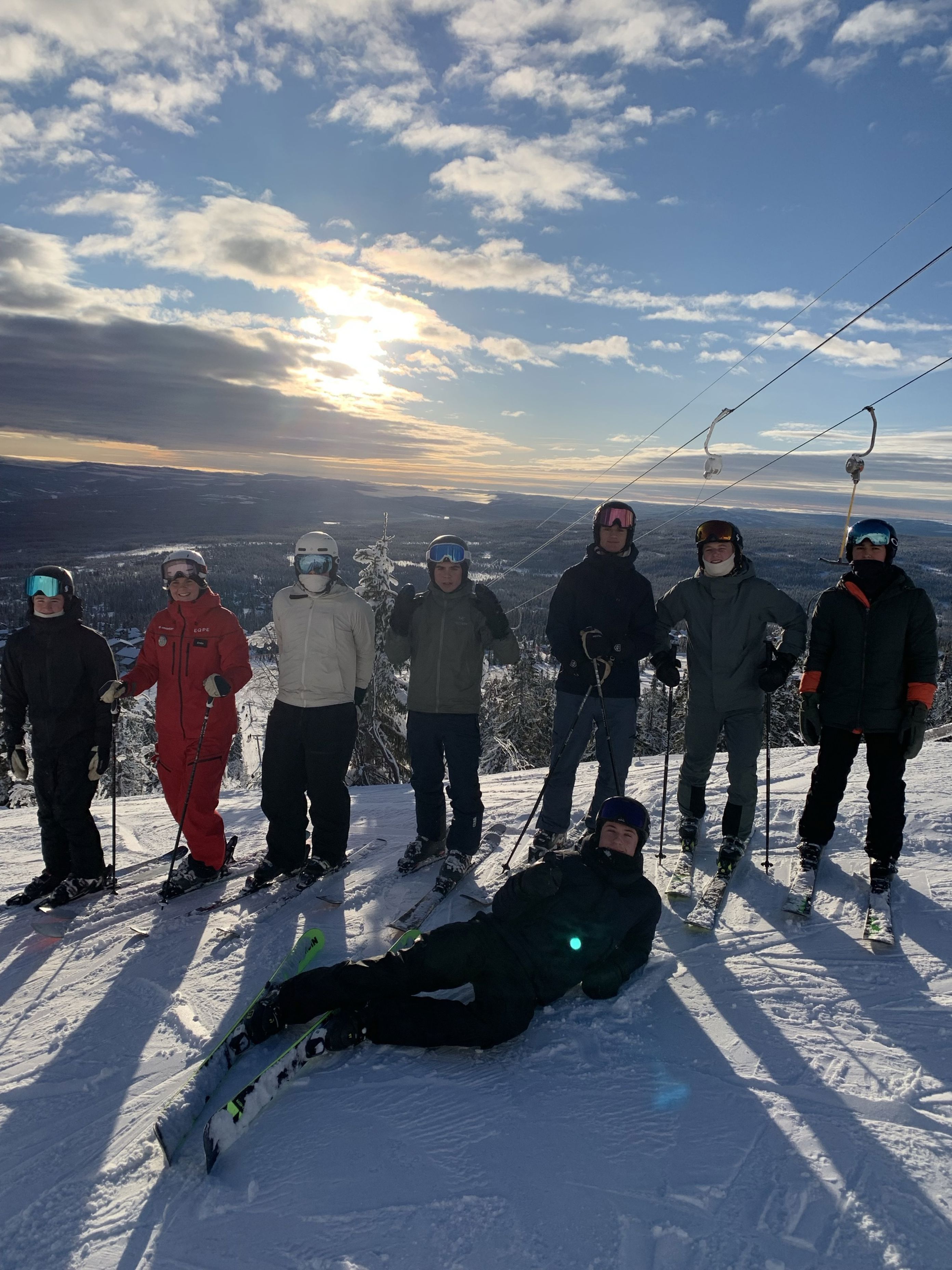 En gruppe mennesker som står på snøski og poserer for et bilde En gruppe mennesker som står på snøski og poserer for et bilde